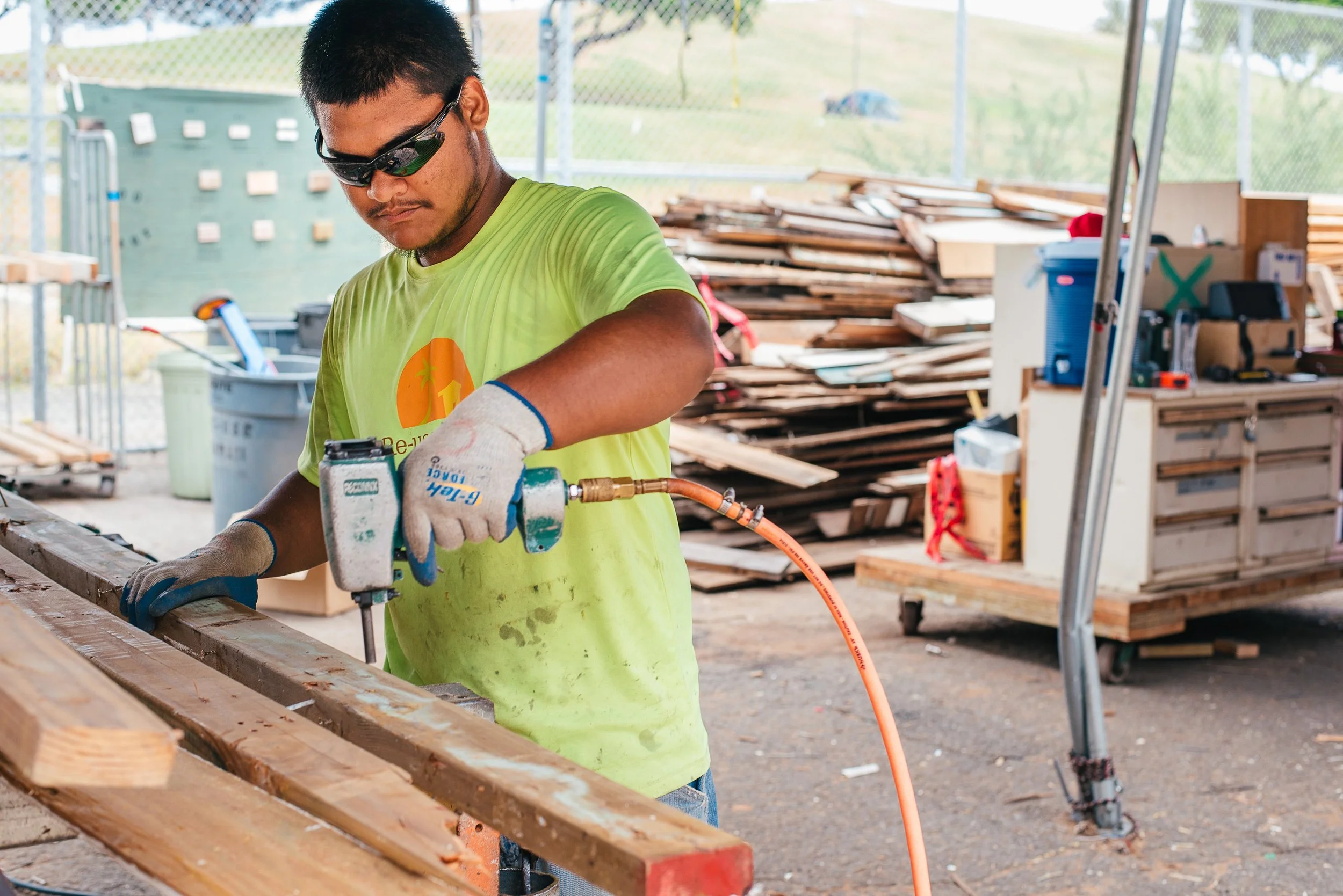 An image of a man using a tool to process used wood to eventually be repurposed.