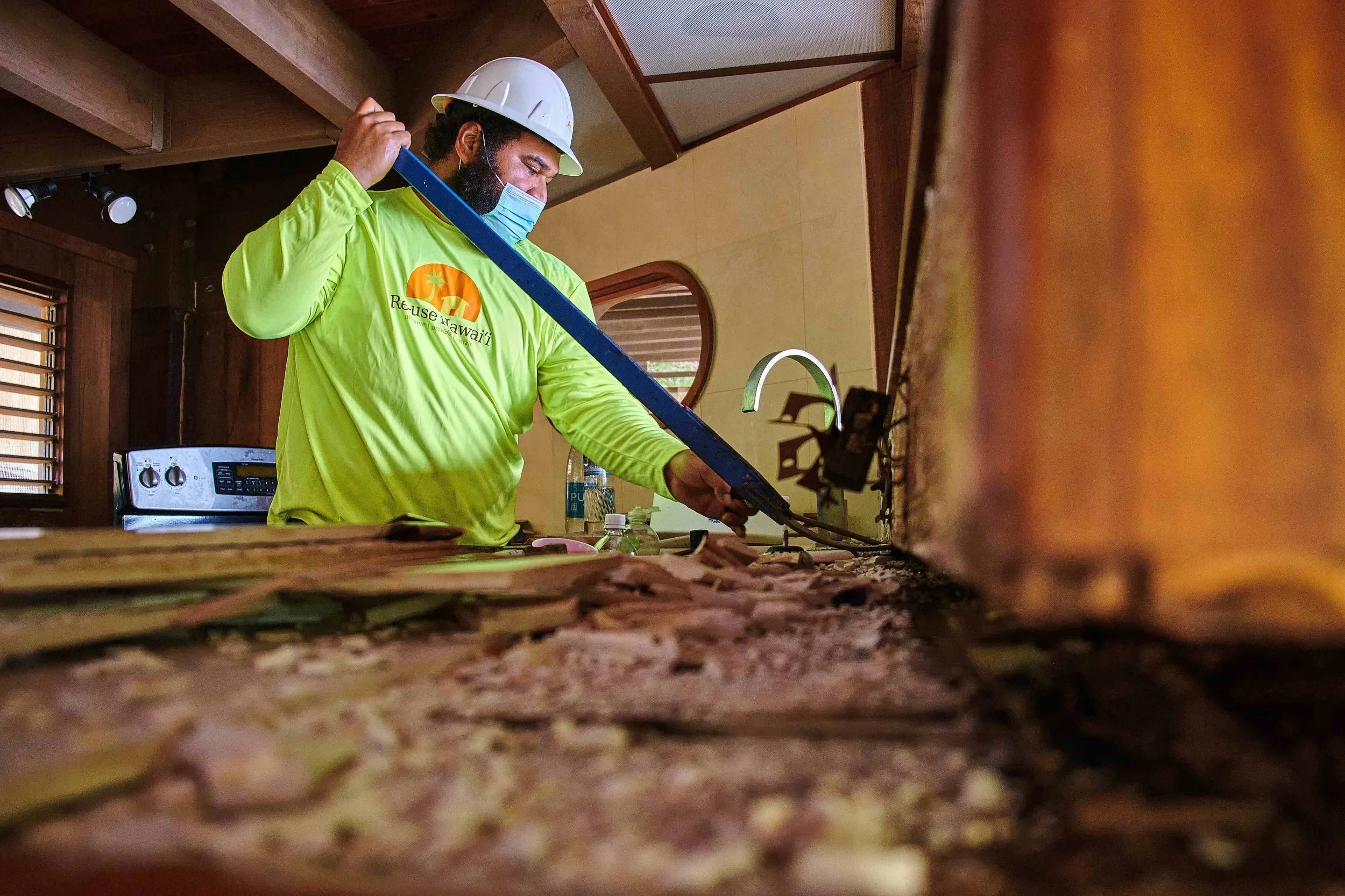 Creative photo of a man using a large tool to lift building materials off a counter.