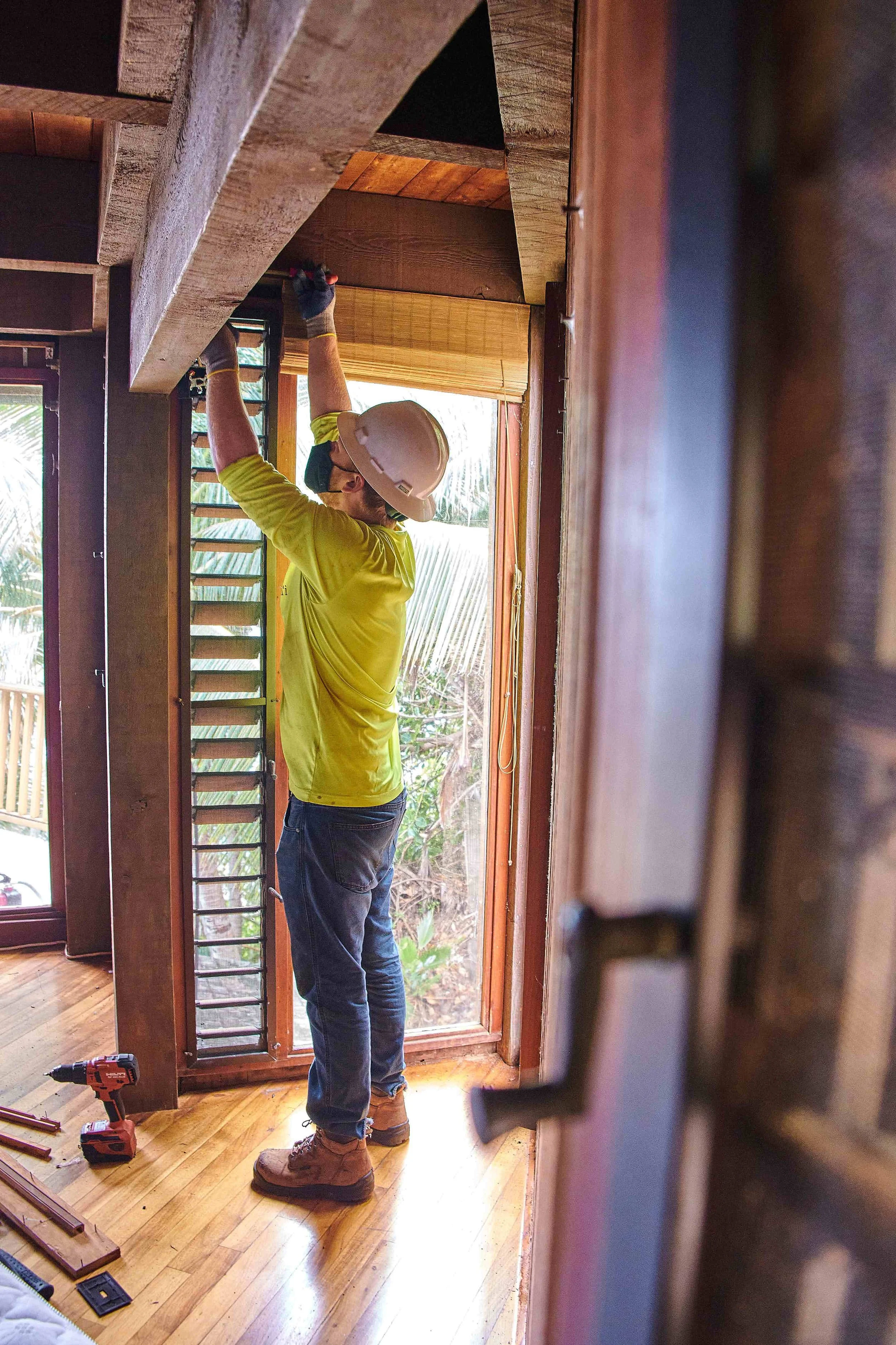 An image of a man working to remove reusable materials from a home to be repurposed.