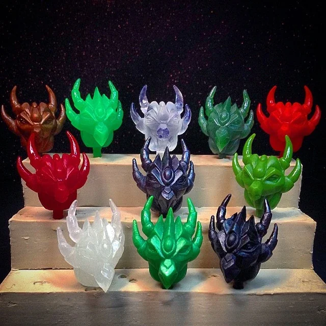 Colorful dragon-shaped candles arranged on a tiered display against a dark, starry background.