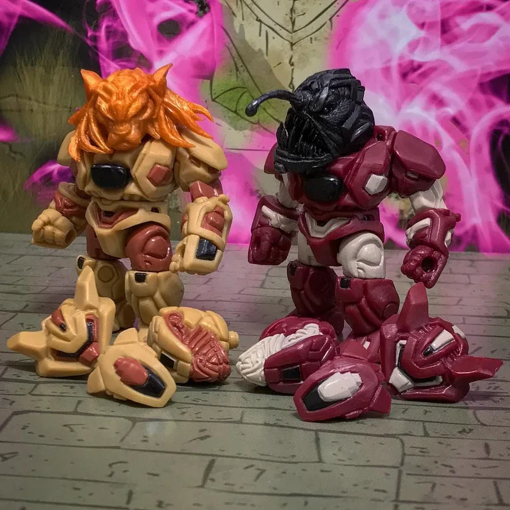 Two action figures in armor, one with orange hair and beige armor, the other with a black insect-like head and red and white armor, standing on a wooden surface with a painted graffiti background.