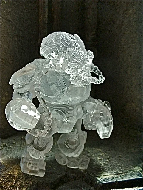 Clear ice sculpture of an astronaut in a space suit with helmet and life support systems.