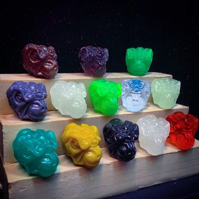 Collection of colorful lion head-shaped soap bars displayed on wooden stairs.