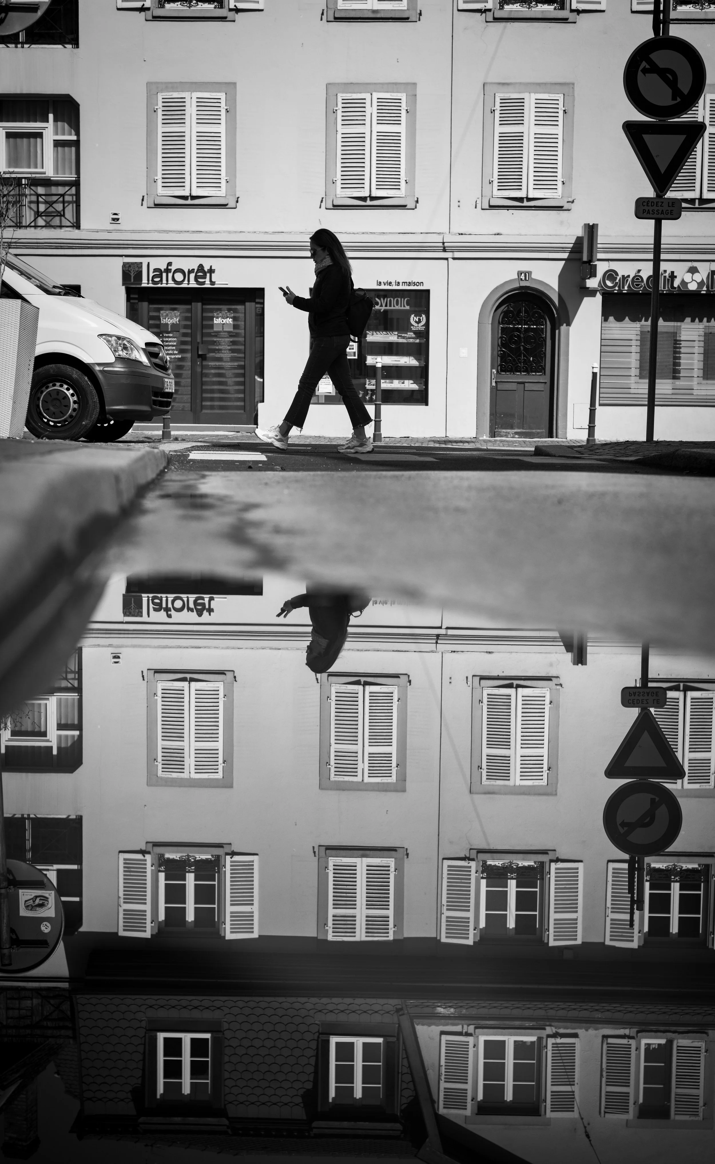Schwarz-Weiß-Fotografie einer belebten Stadtstraße mit Passantin