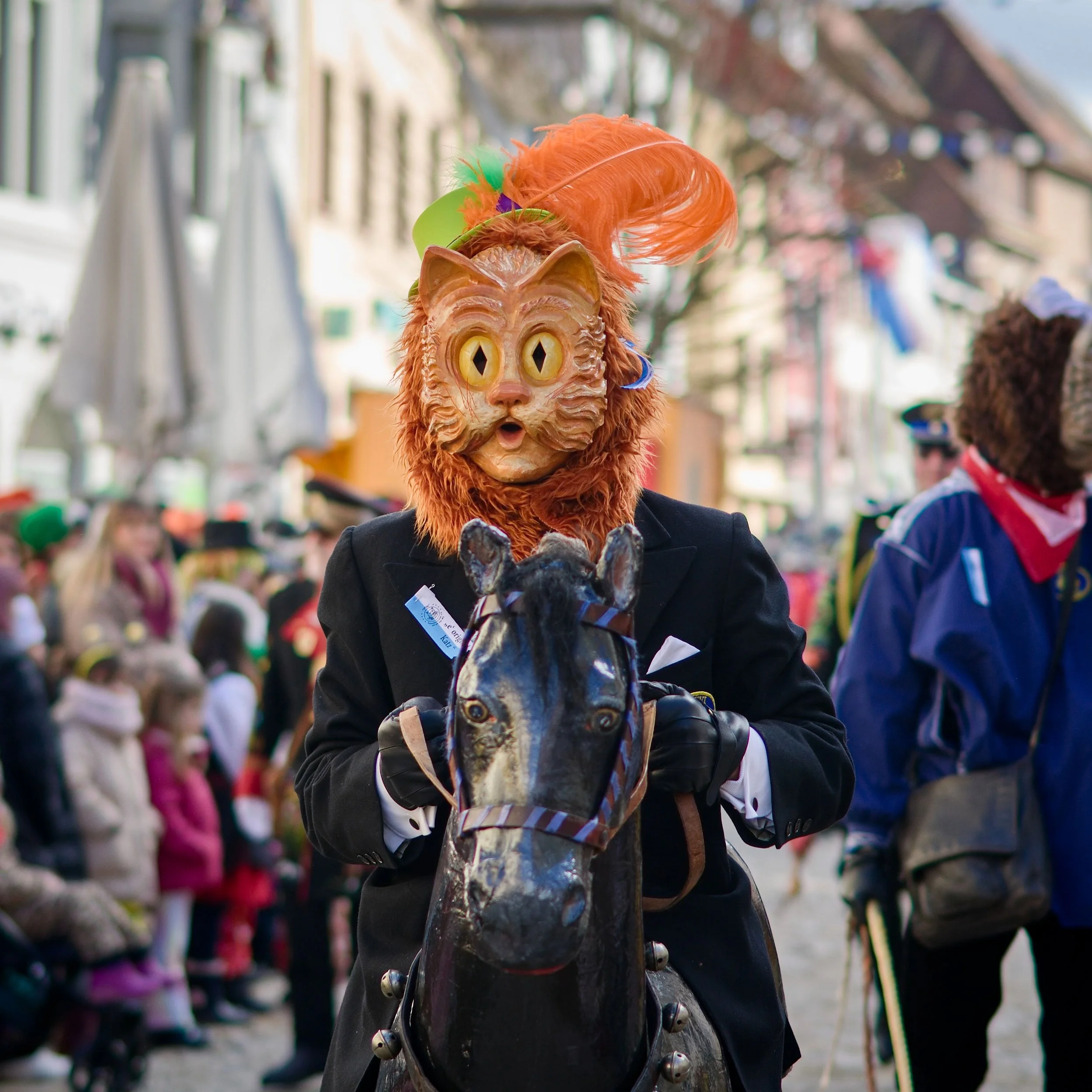 Fasnetfigur mit Katzenmaske auf einem Holzpferd beim Umzug in Villingen