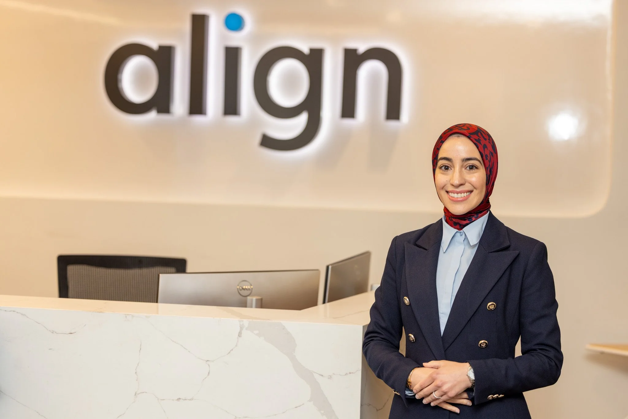 Corporate portrait of a professional standing at the Invisalign office reception desk, corporate photography by David Pierre Studio
