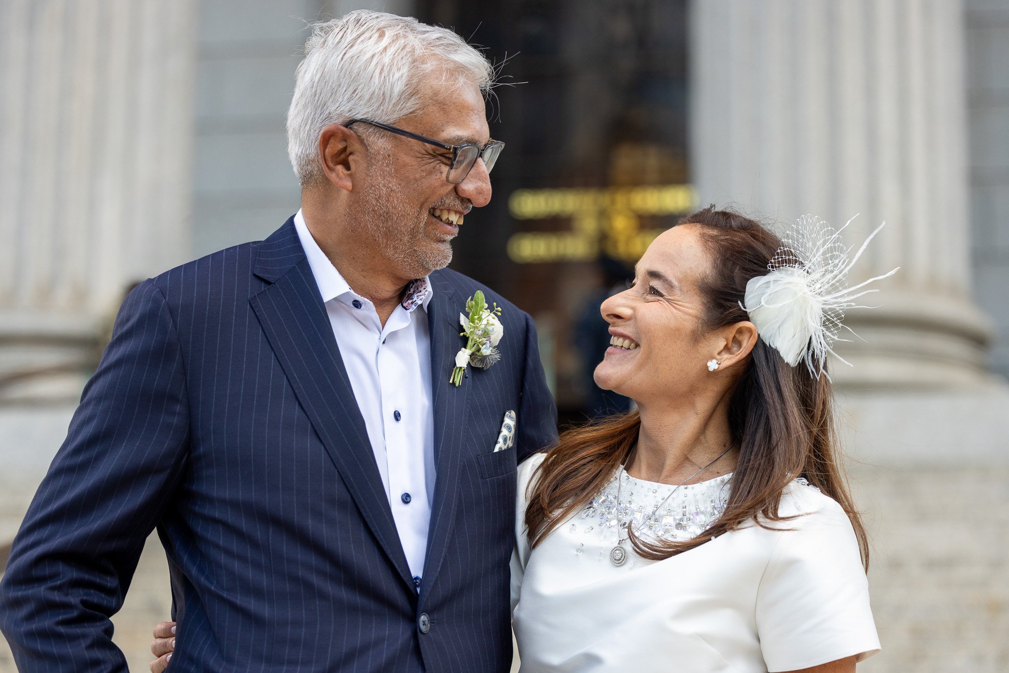 Couple smiling together outside a historic courthouse on their wedding day, wedding photography by David Pierre Studio