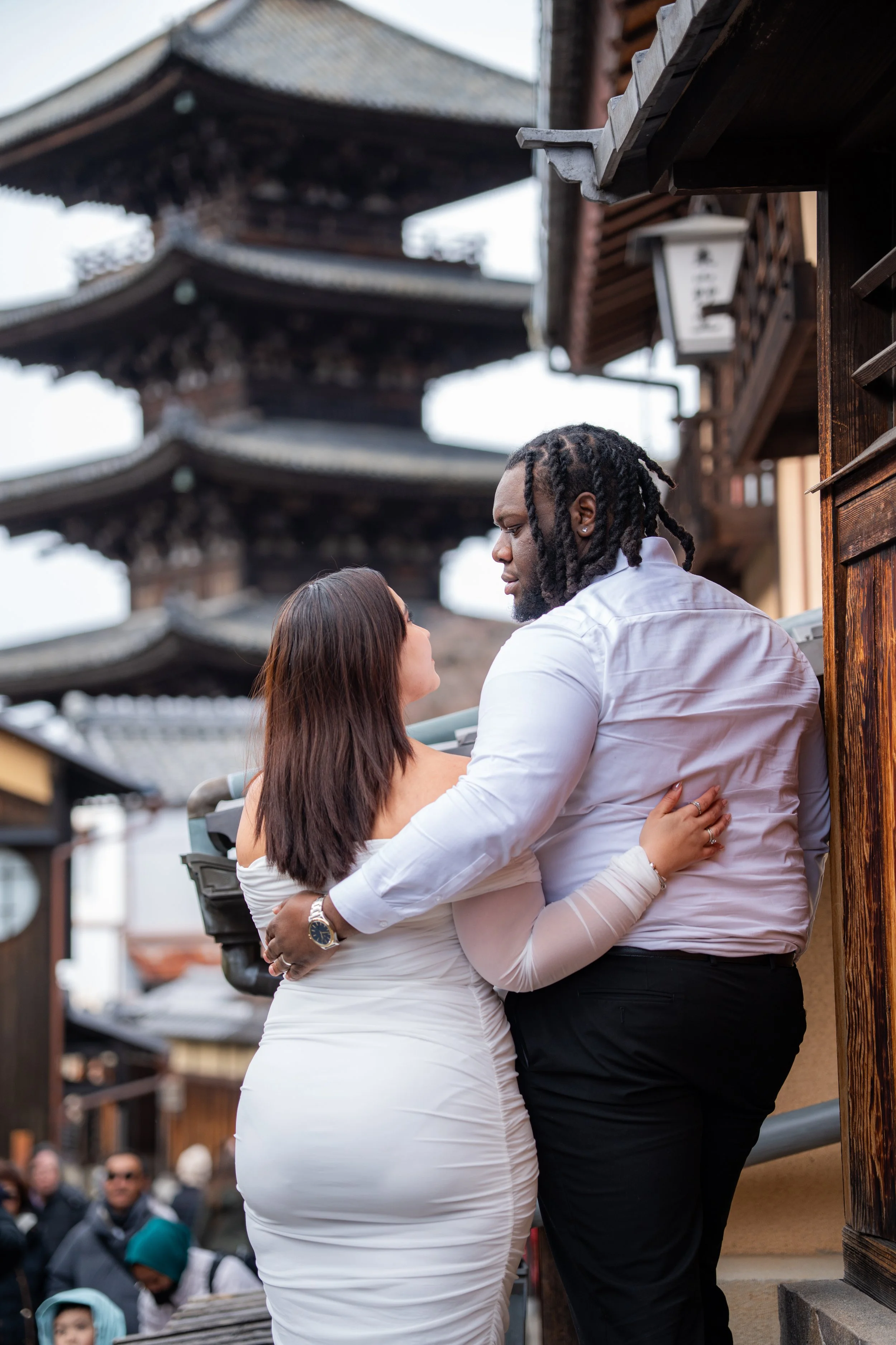 Couple starring at each other in formal clothes.  outside of kyoto temple in Japan