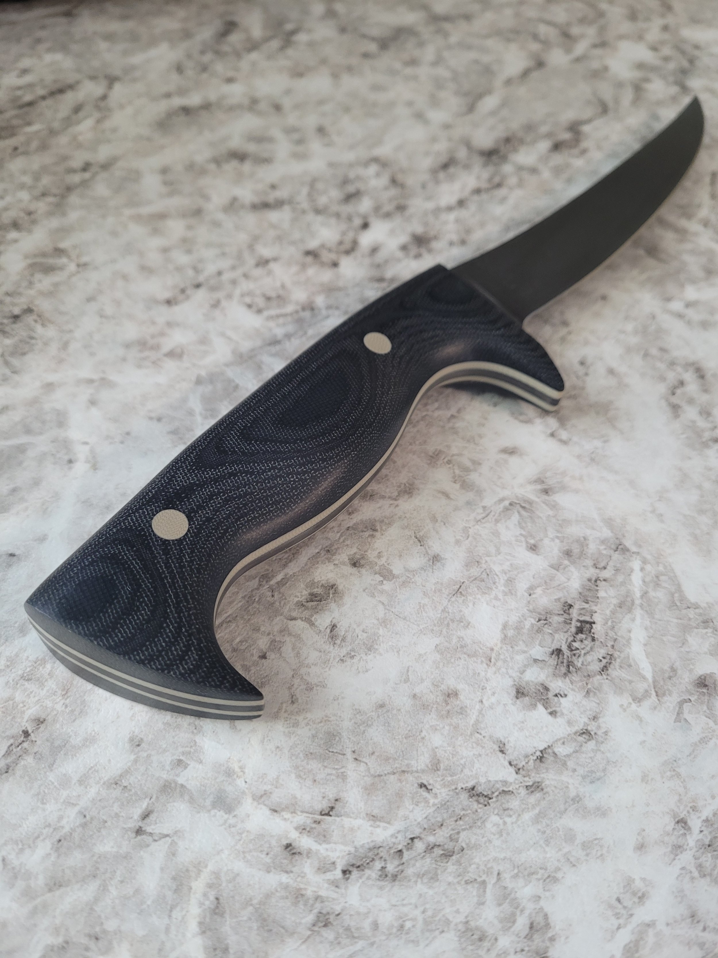 Black micarta with tan G10 liners and pins.
