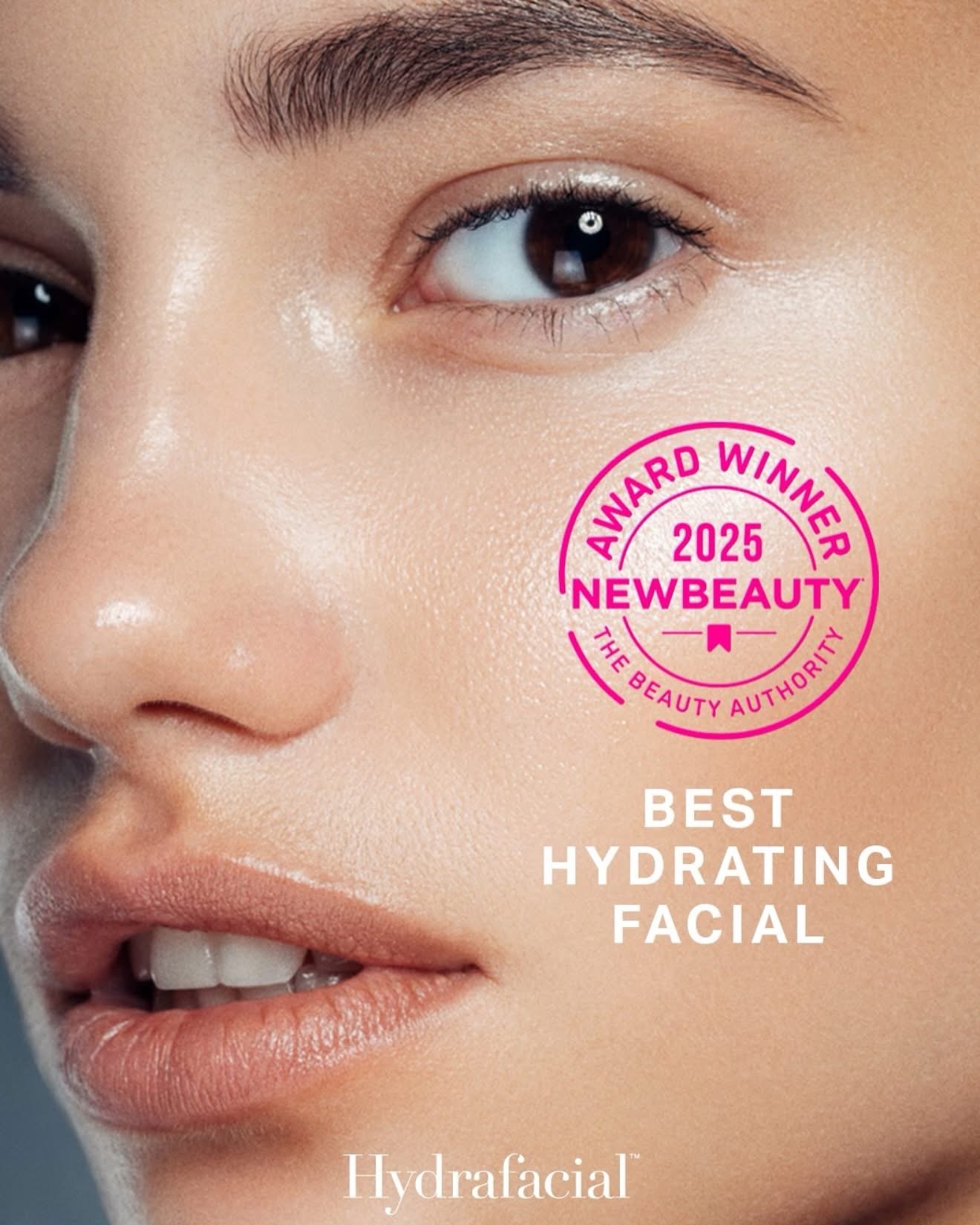 Close-up of a woman's face with clear, glowing skin, and a pink award badge on the right side that says '2025 Award Winner, NewBeauty, The Beauty Authority, Best Hydrating Facial.'