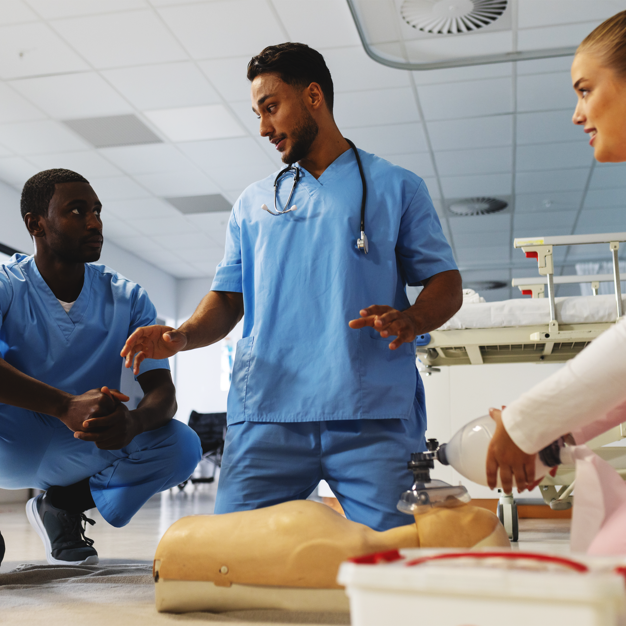 Medical professionals practicing CPR on a mannequin in a training room.
