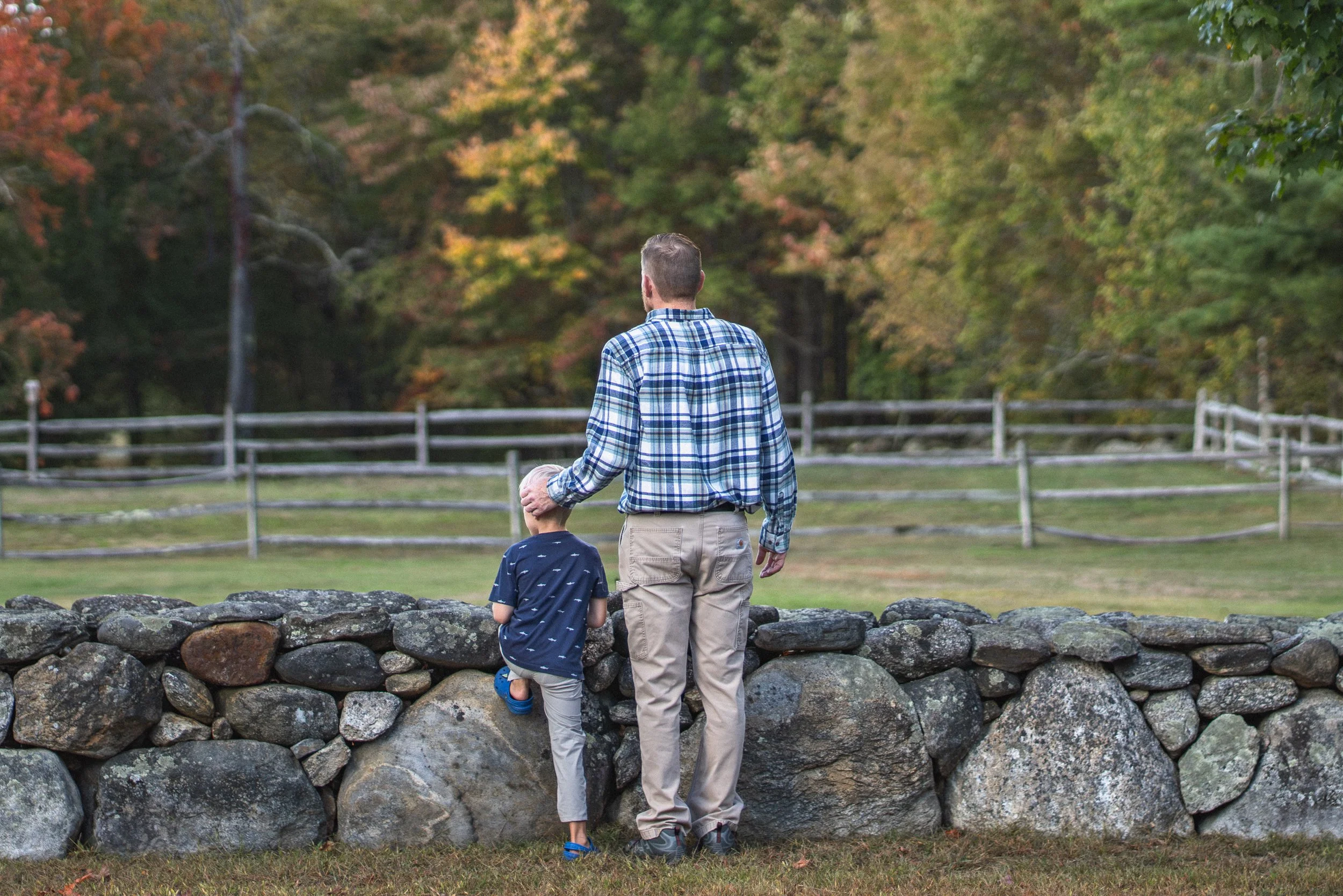 Father and son standing together outdoors during a candid family photography session in Central Massachusetts.