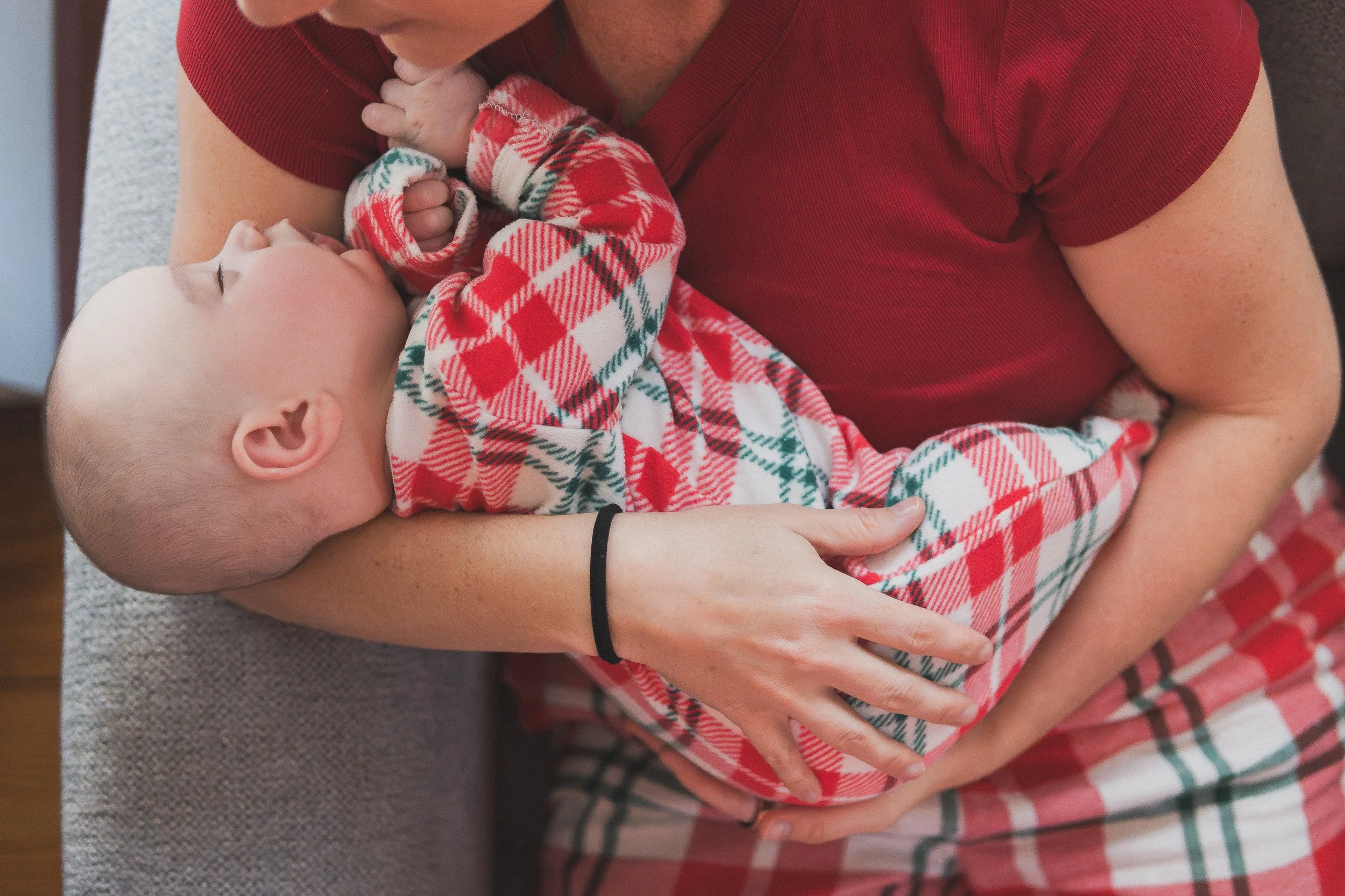 close-up-parent-holding-newborn-holiday-pajamas-lifestyle-photo.jpg