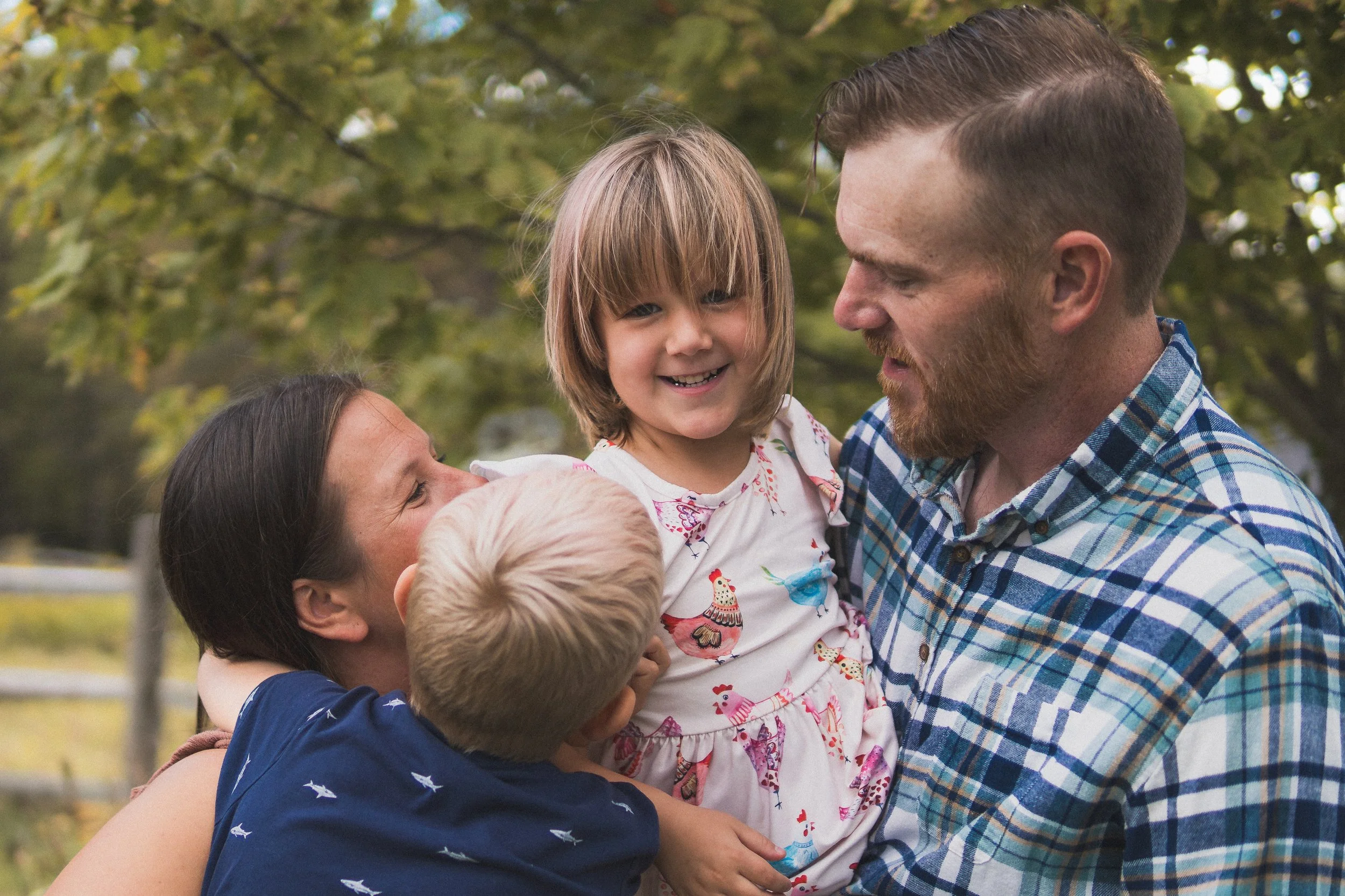 Lifestyle family photography session in Central Massachusetts featuring parents and children sharing a natural, candid moment outdoors.