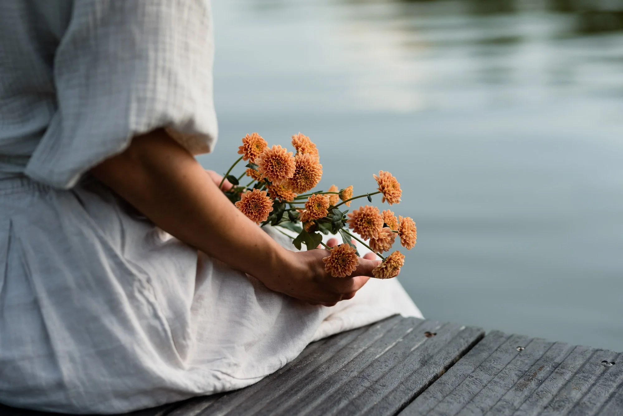 Side Woman holding Flowers on a dock