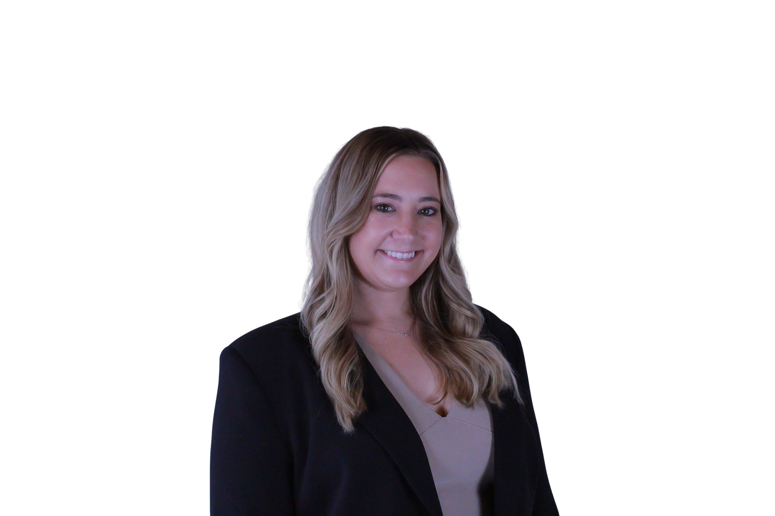 A woman with long blonde hair, wearing a black blazer and beige top, smiling at the camera against a dark background.