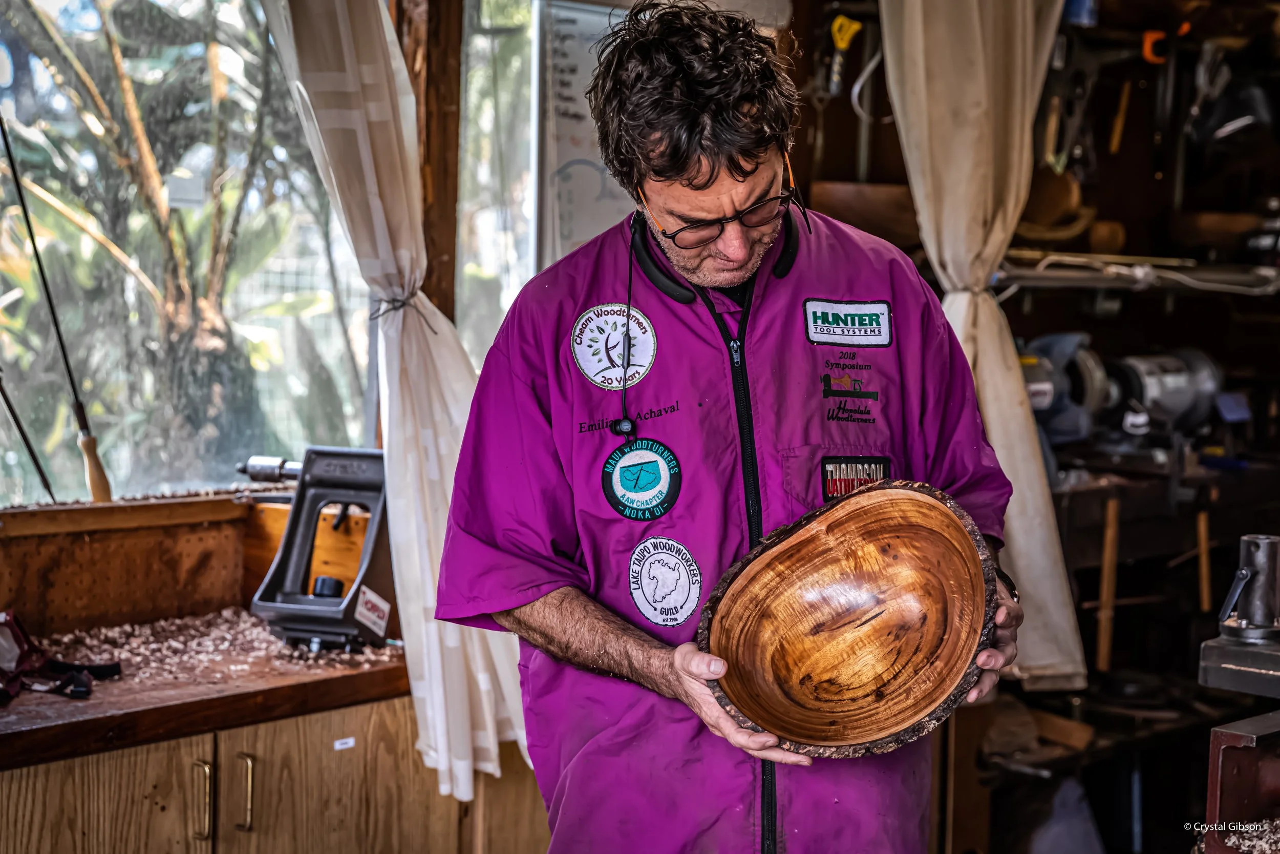 Emiliano Achaval woodturner holding a natural edge bowl made with hawaiian native Koa wood that his just finished in his  woodworking workshop.