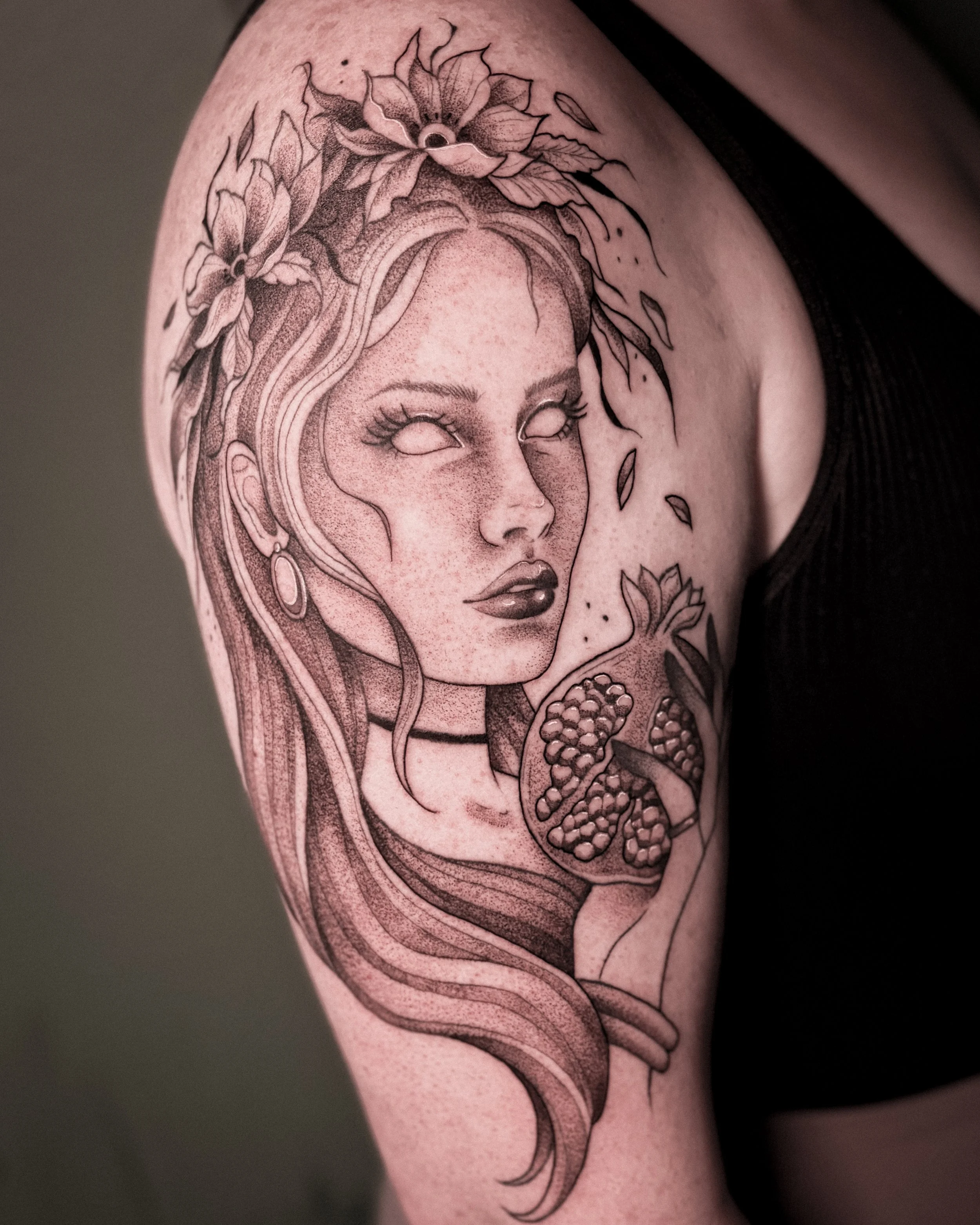 Tattoo of Persephone with flowers and pomegranate elements.