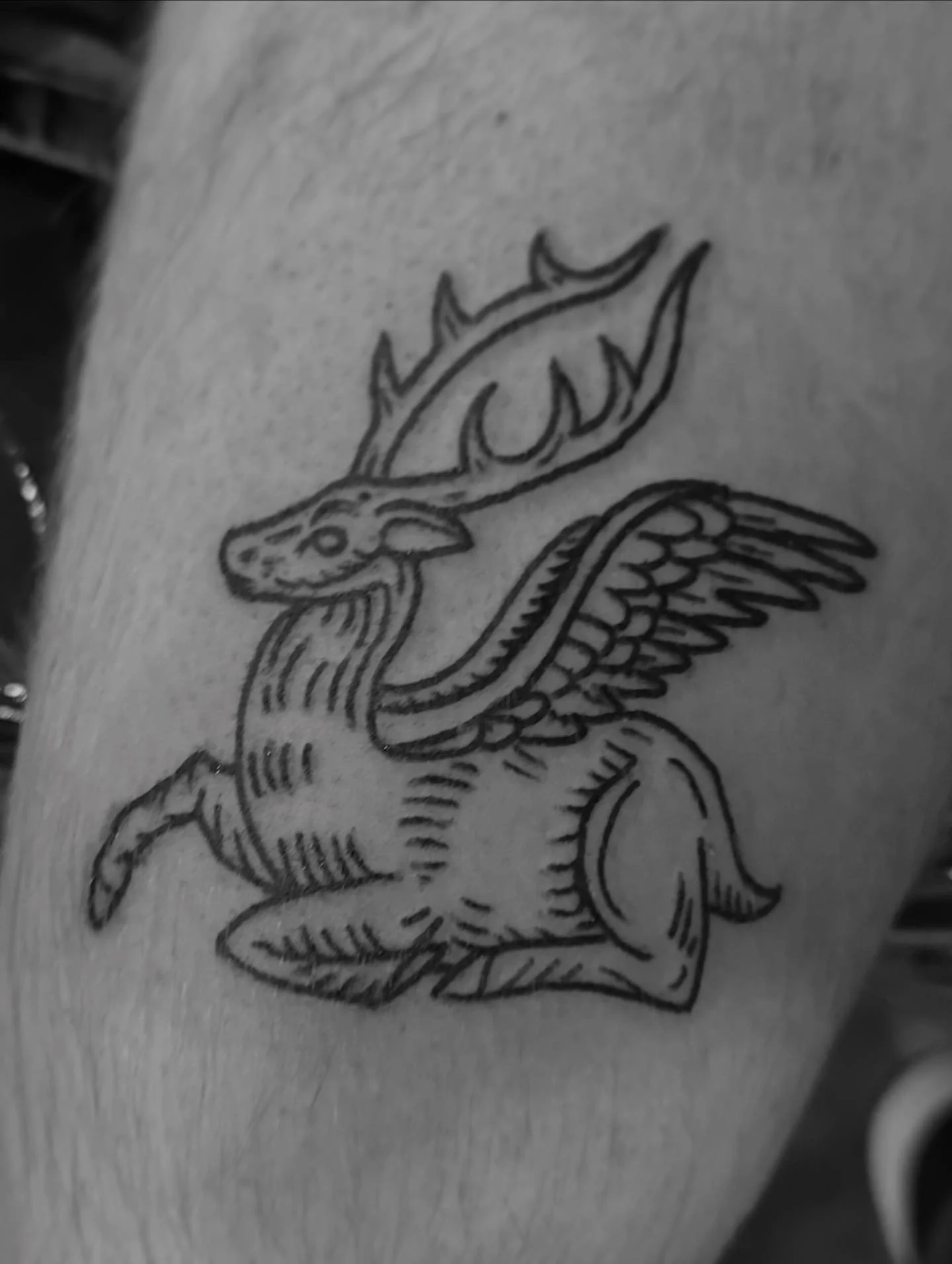 Black ink tattoo of a peryton.