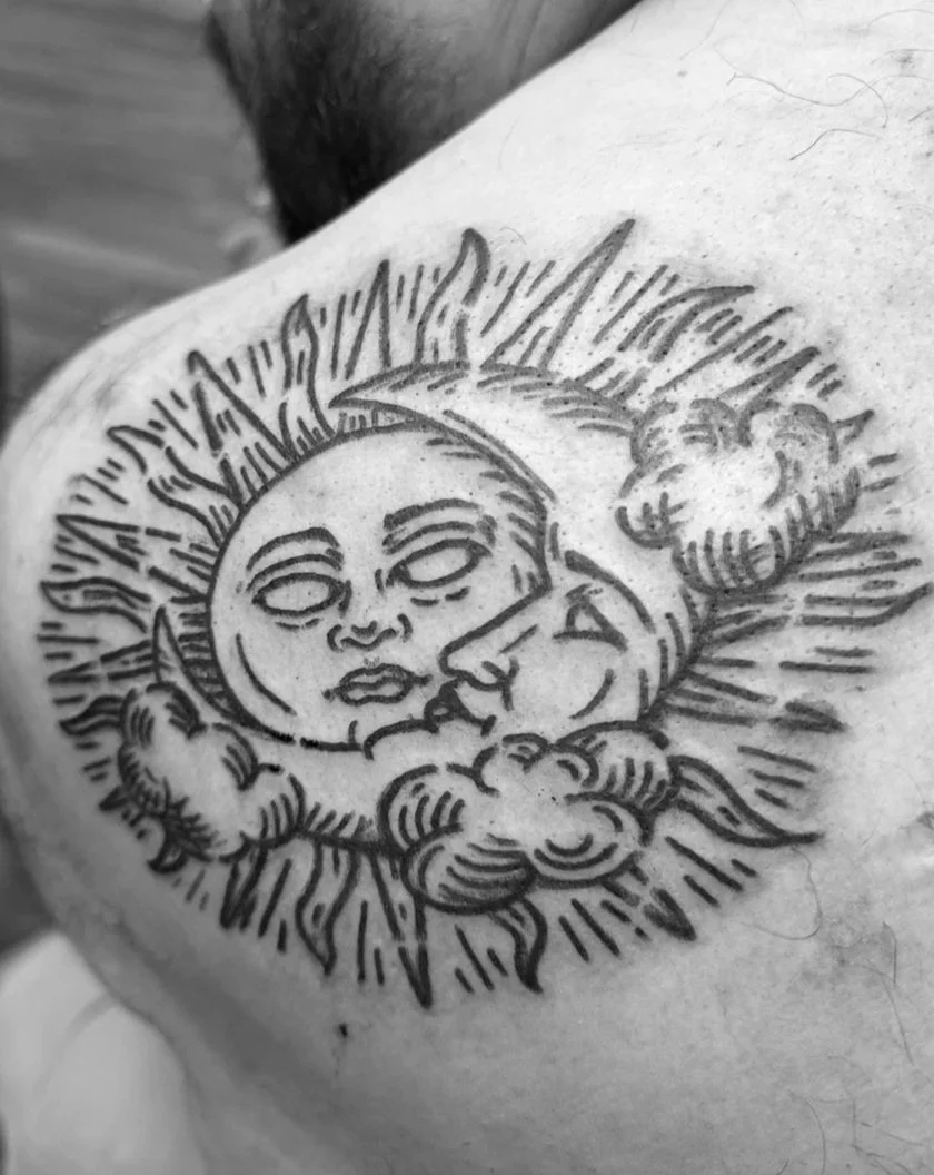 Black ink sun and moon tattoo.