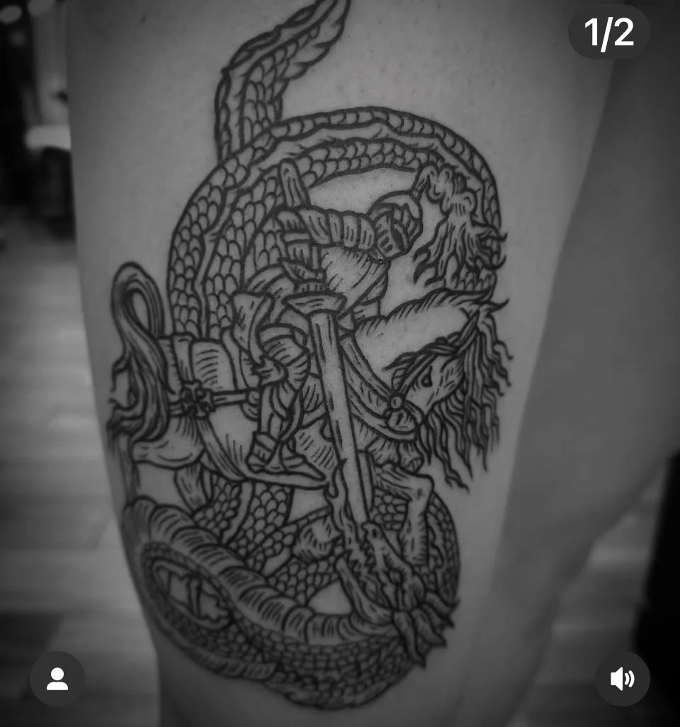 Black ink tattoo of St. George on horseback fighting a dragon.