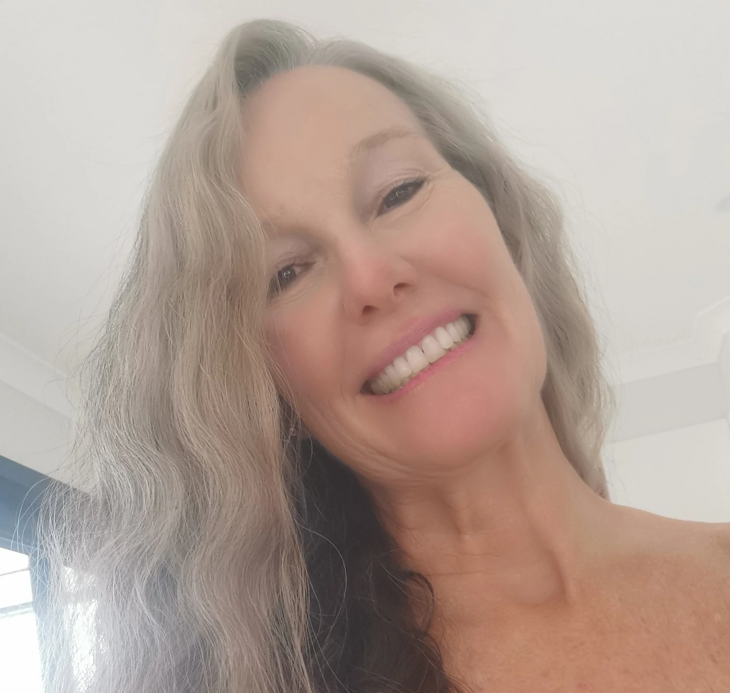 Close-up of Felicity Rutherford artist - smiling. She has wavy blonde hair and looks very happy.