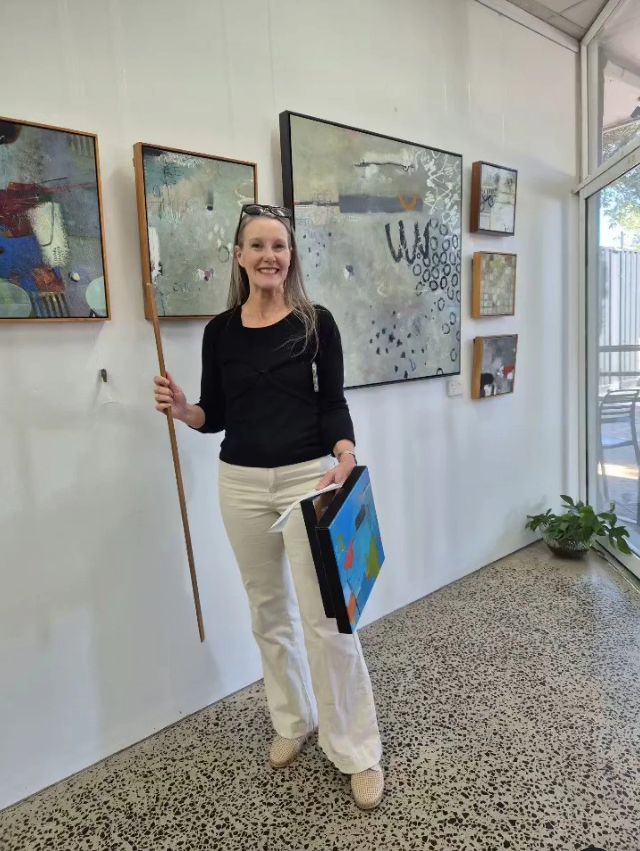 Felicity standing in an art gallery, with abstract artwork on the wall.