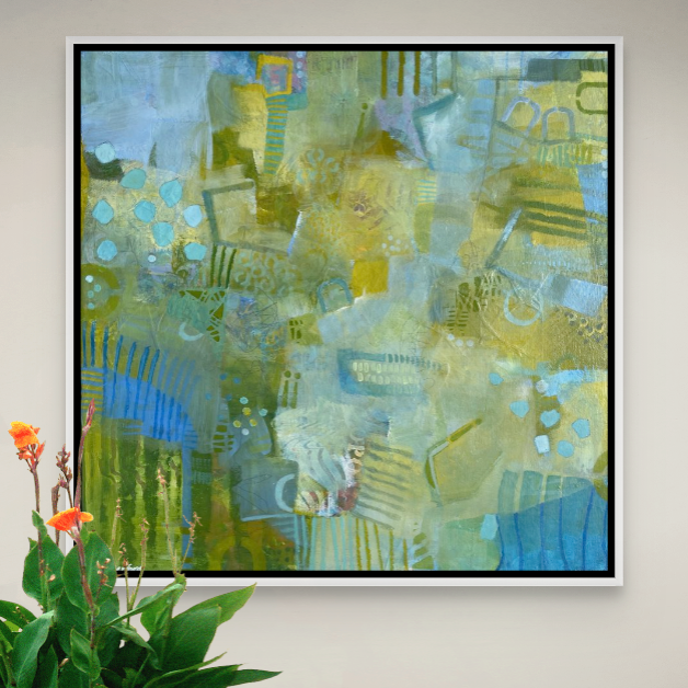 Abstract green, blue, yellow, and orange painting hanging on a white wall, with a green plant with orange flowers in the foreground.