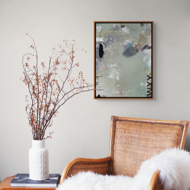 Interior corner with a wooden chair, white fluffy cushion, tall white vase with dried branches, abstract artwork on the wall.