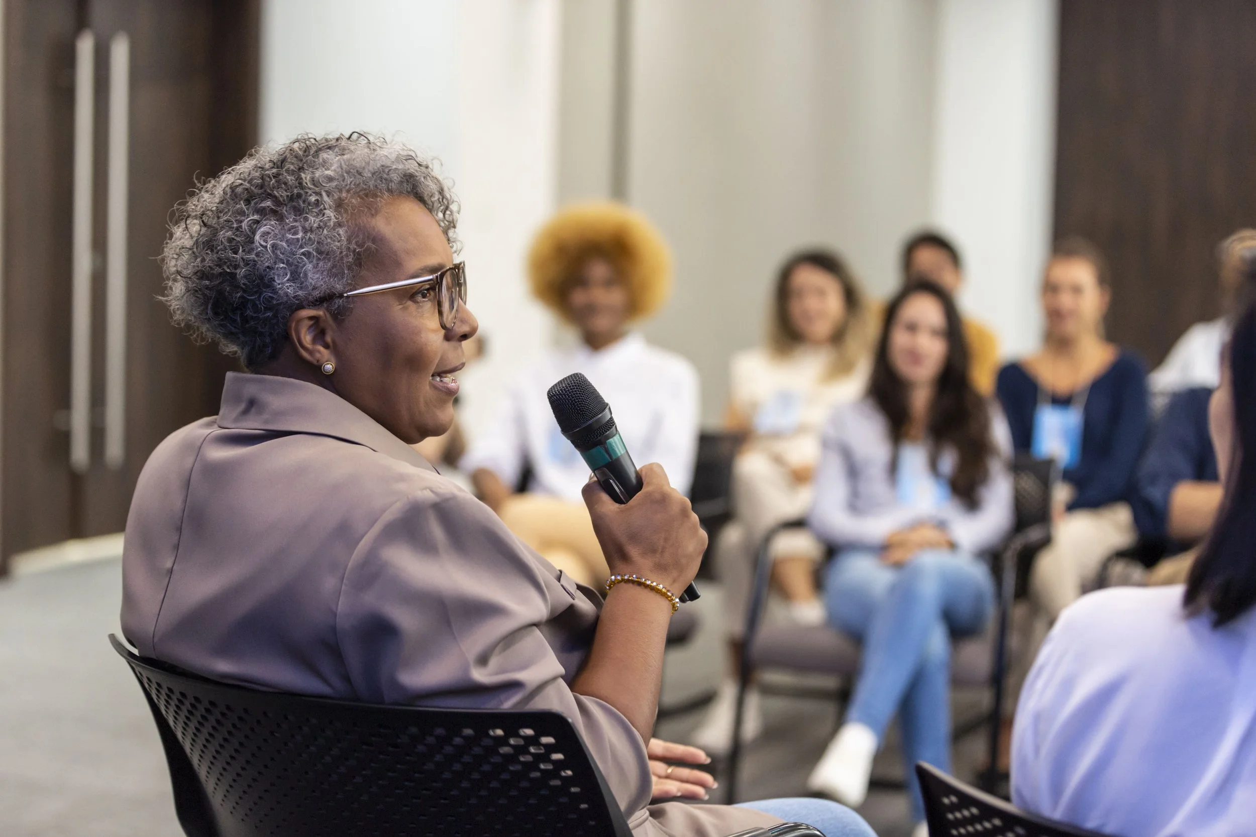 black woman sitting and speaking into a microphone