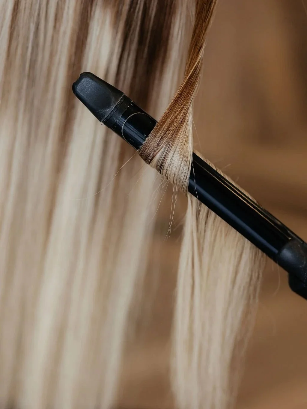 Close-up of a black marker tucked into a section of light blonde hair.