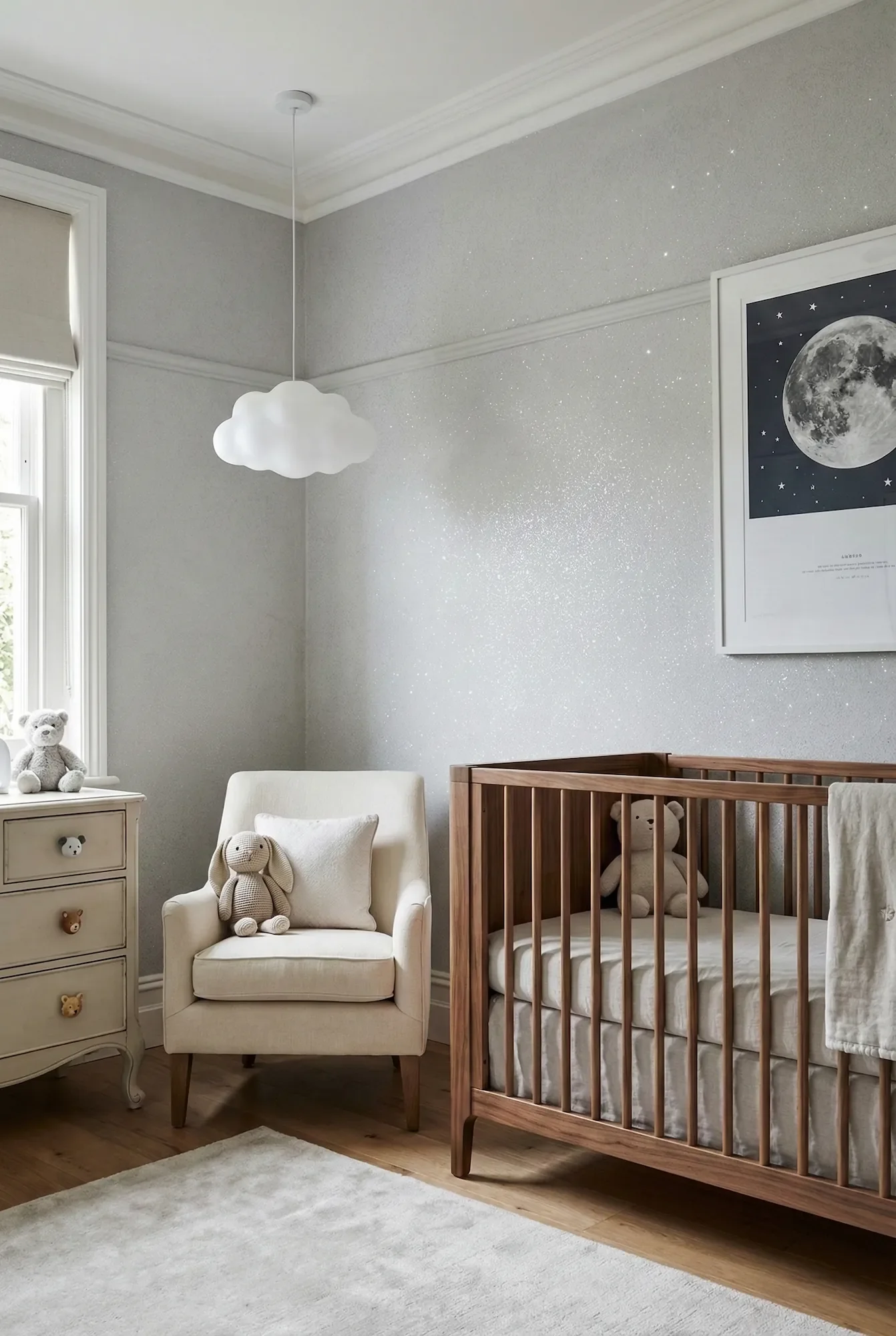 A serene and whimsical luxury nursery featuring a shimmering silver glitter Venetian plaster accent wall that creates a starry sky effect, styled with a modern wooden crib and a cloud pendant light.
