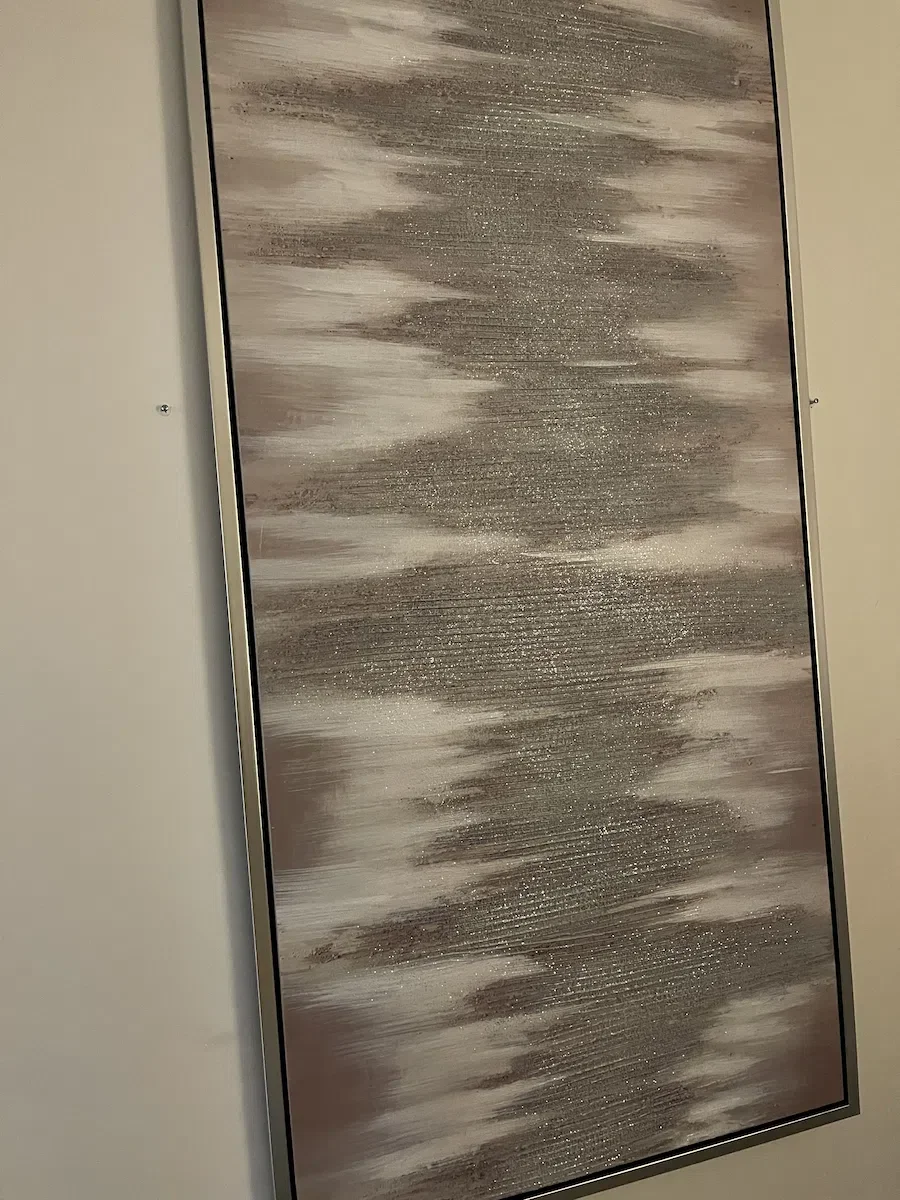 Framed custom textured plaster art panel with shimmering silver and taupe horizontal glitter finish at Esencia Salon and Spa.