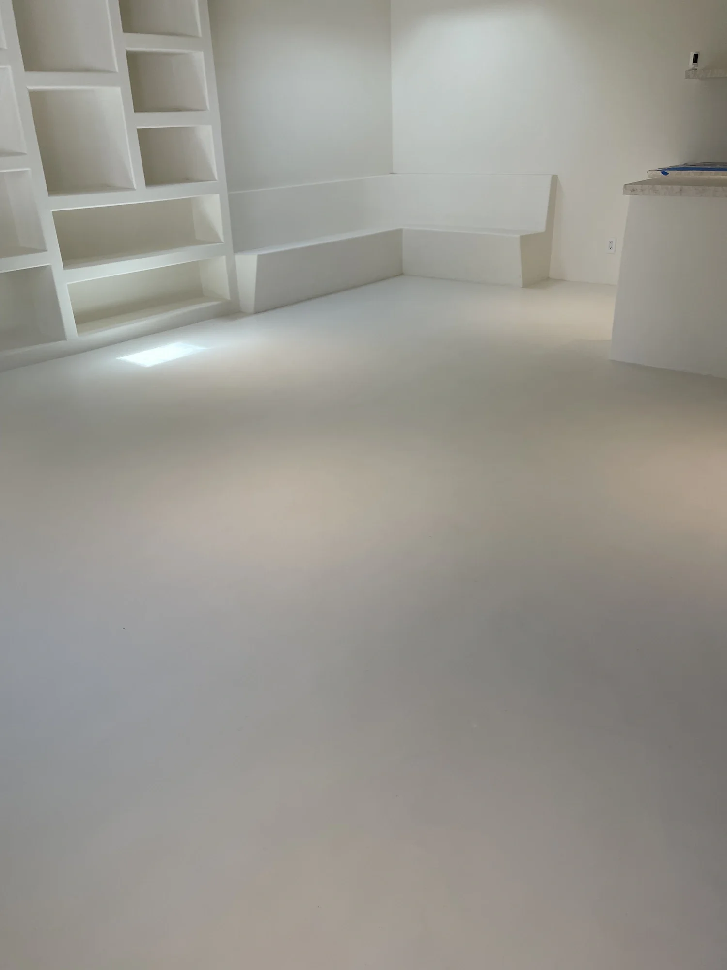 white-seamless-microcement-living-room-floor.webp