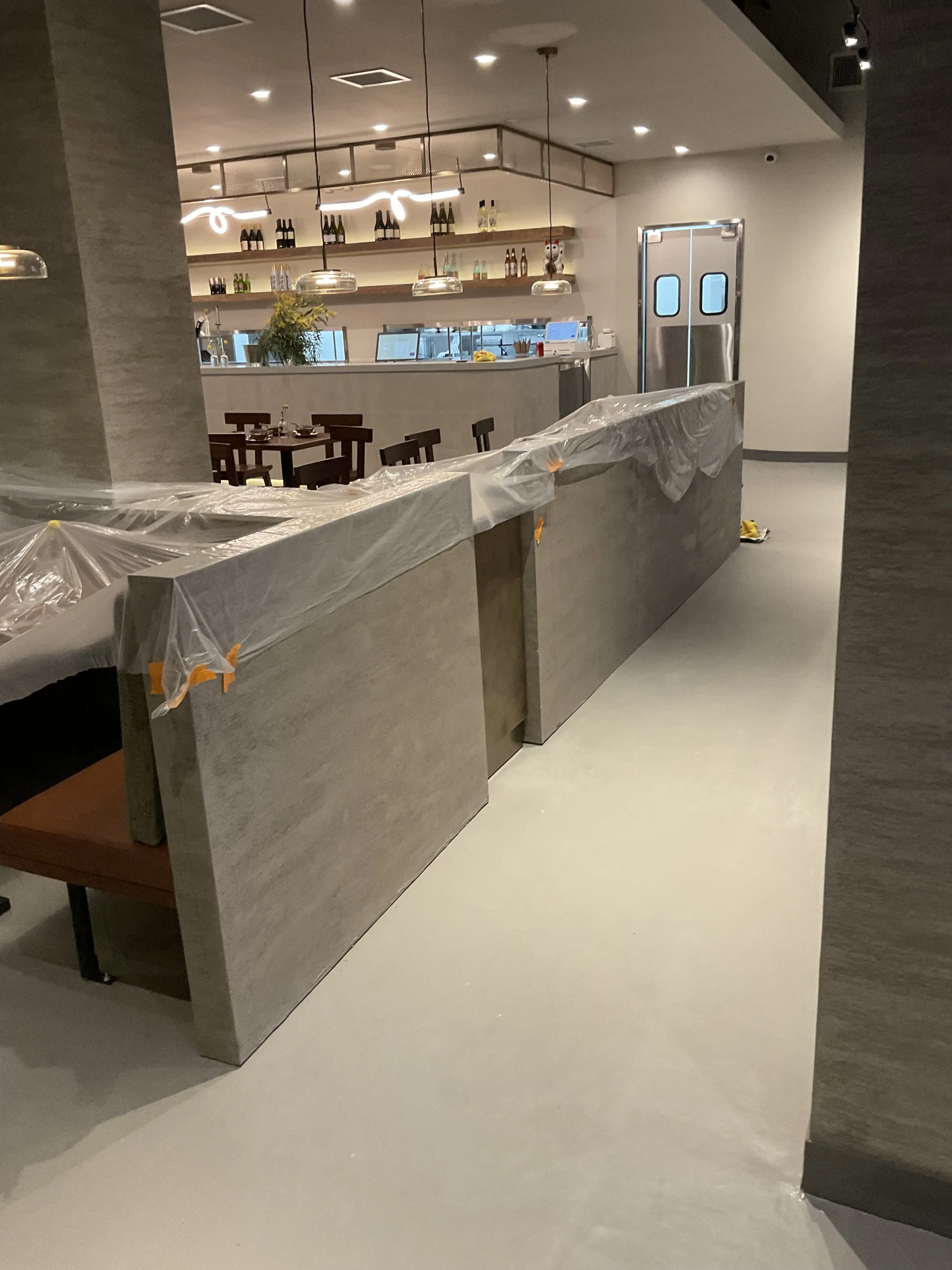 Low interior partitions and structural columns finished in a light grey textured Venetian plaster at Sichuan Impression restaurant in Alhambra.
