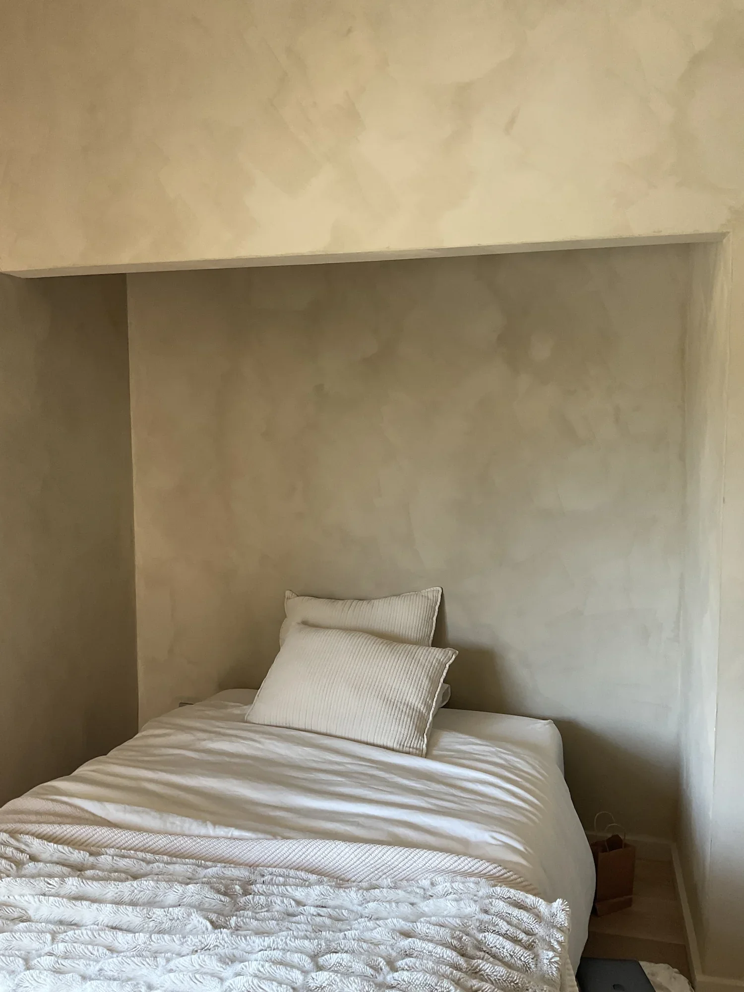 earthy-beige-limewash-plaster-bedroom-accent-wall.webp