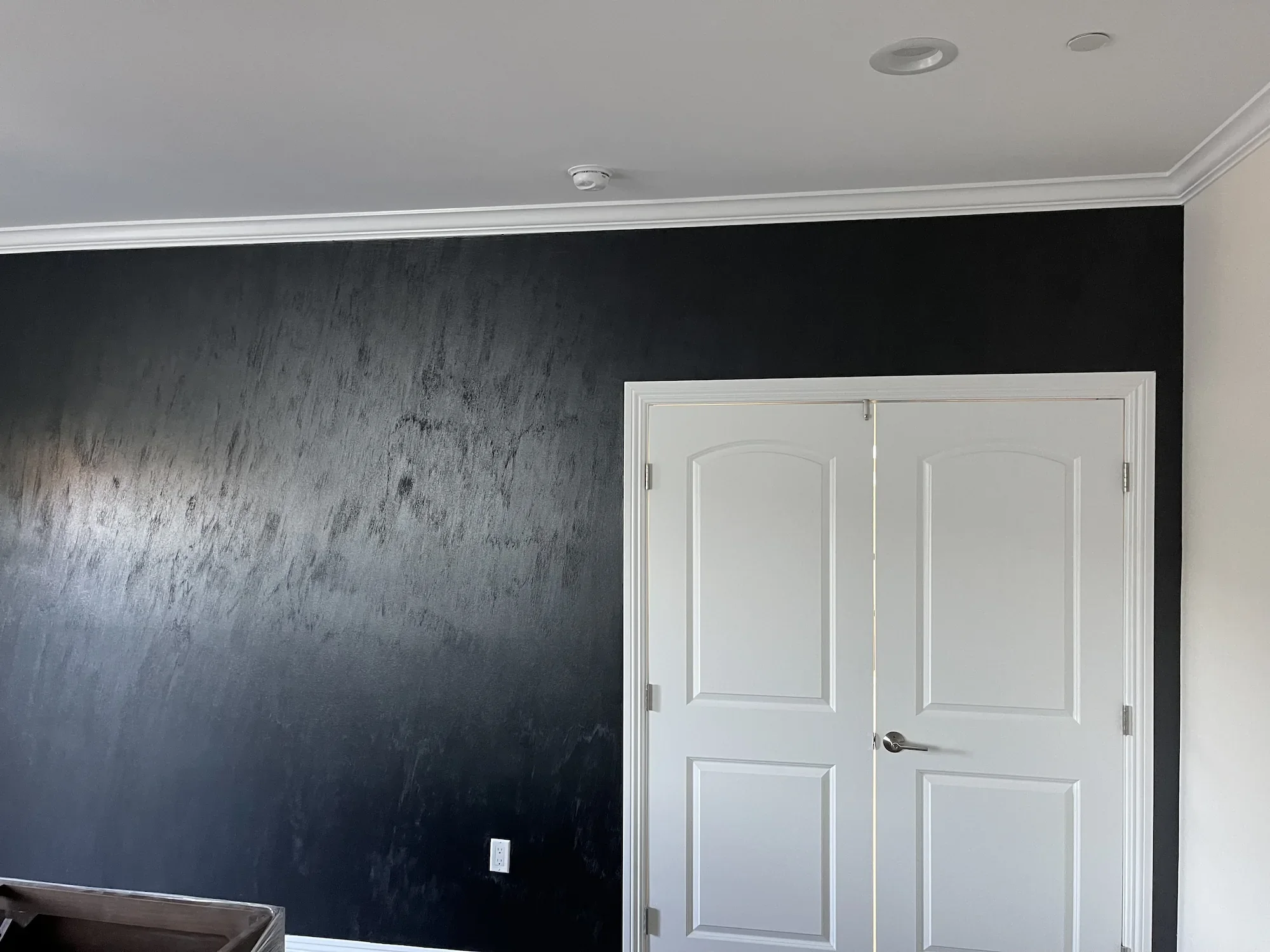 metallic-sahara-venetian-plaster-black-accent-wall.webp