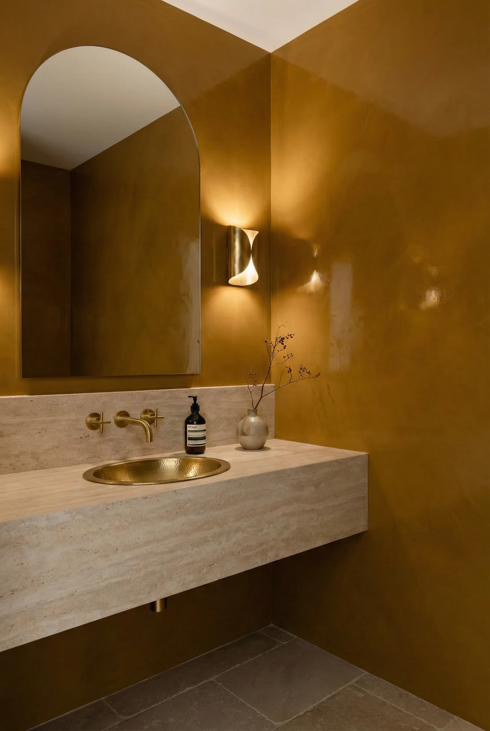High-gloss Venetian plaster walls in a luxury bathroom, featuring a hand-applied polished plaster finish in warm golden ochre tones with subtle trowel marks, soft reflective sheen, and seamless corners that enhance depth and ambient lighting.