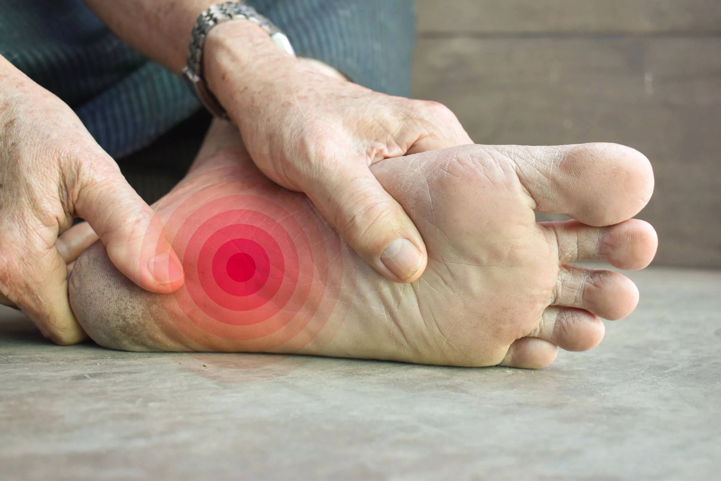 Close-up of a person holding their ankle with a red target overlay indicating pain or injury.