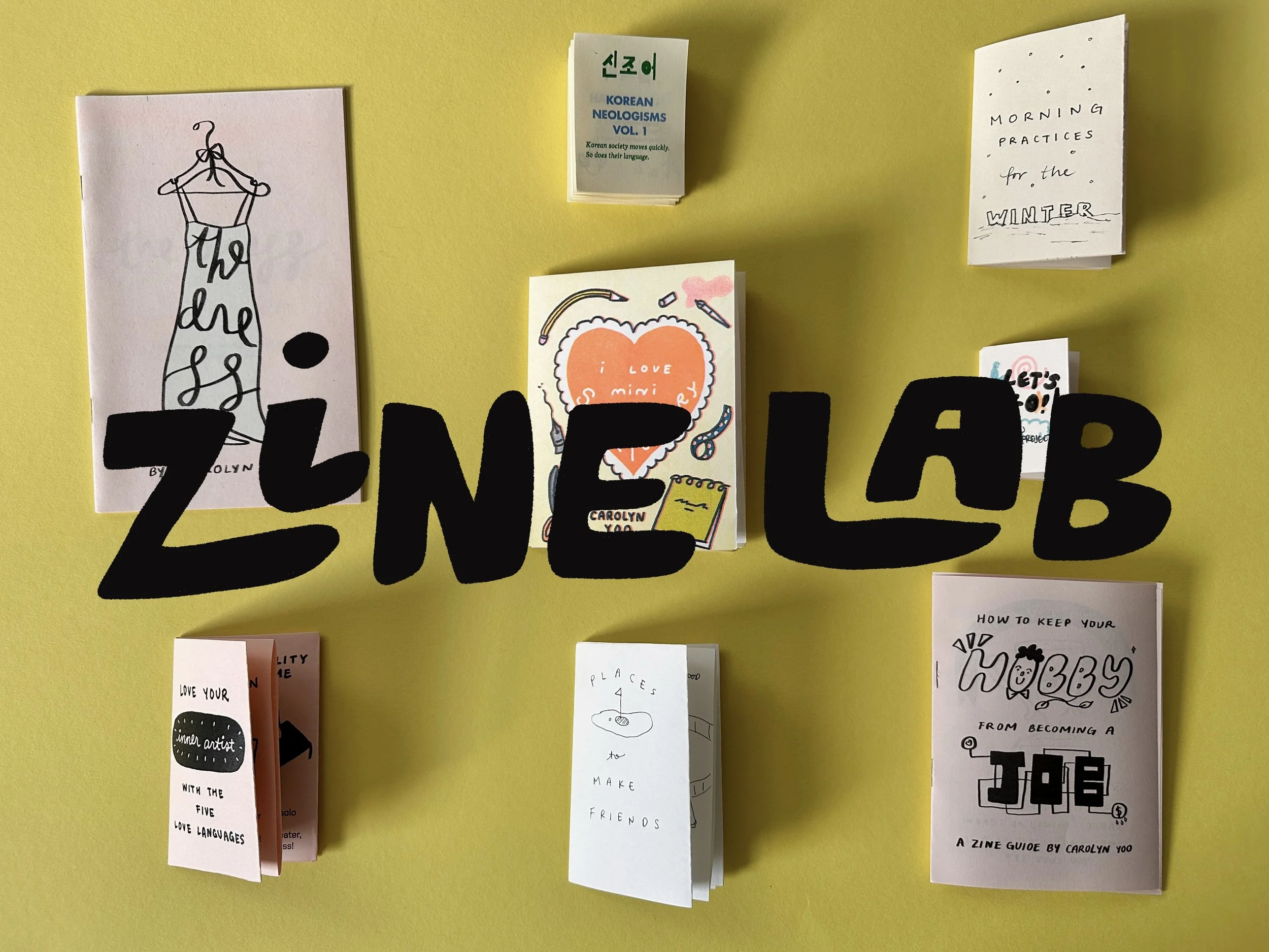 Yellow background with various zines. Large black cut-out letters spell 'ZINE LAB' across the center.