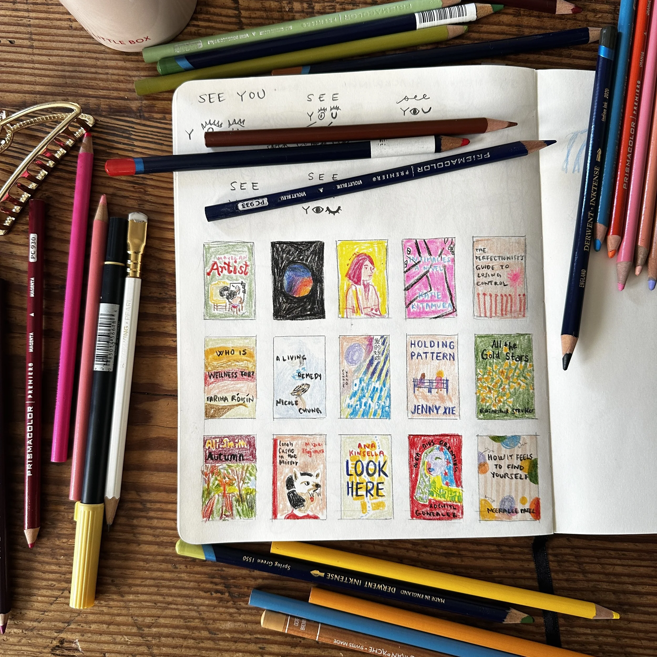 A sketchbook open on a wooden table, featuring colorful drawings and handwritten titles of books. Surrounding the sketchbook are various colored pencils, pens, and other art supplies.