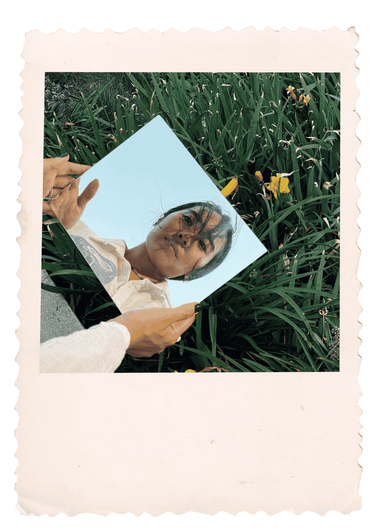 Carolyn Yoo holding a mirror outdoors, capturing her reflection against tall grass.