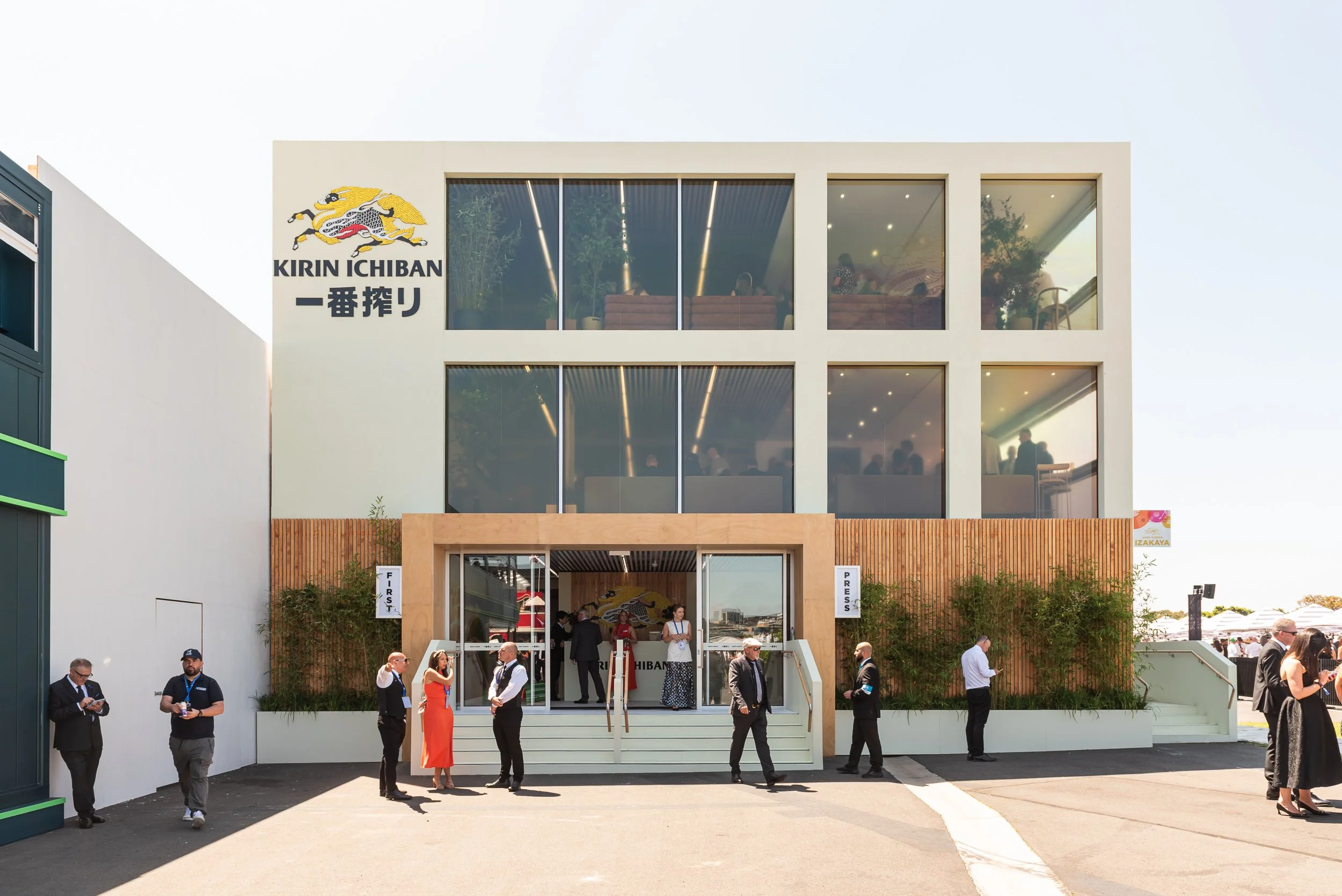 Modern three-story building with large glass windows and a sign reading 'KIRIN ICHIBAN' with Japanese characters, a lion logo, and people entering and standing outside.