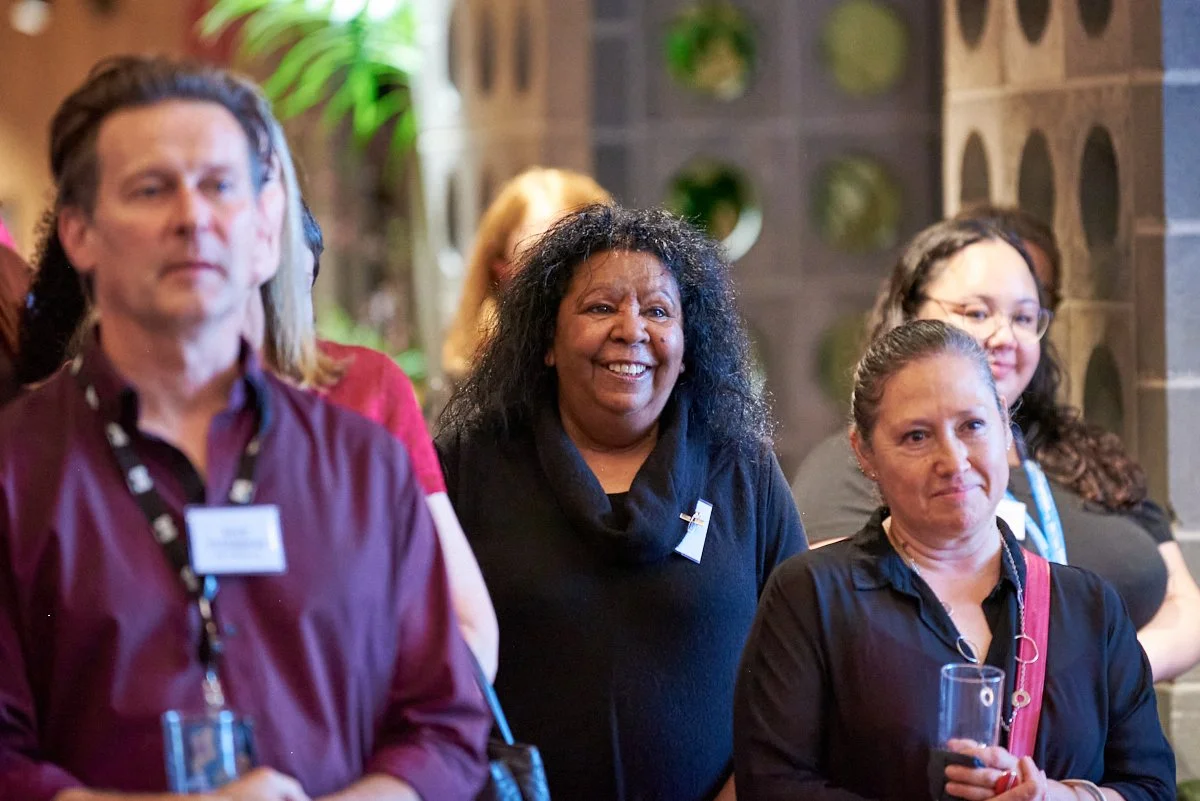 Group of women at a social event, smiling and holding drinks