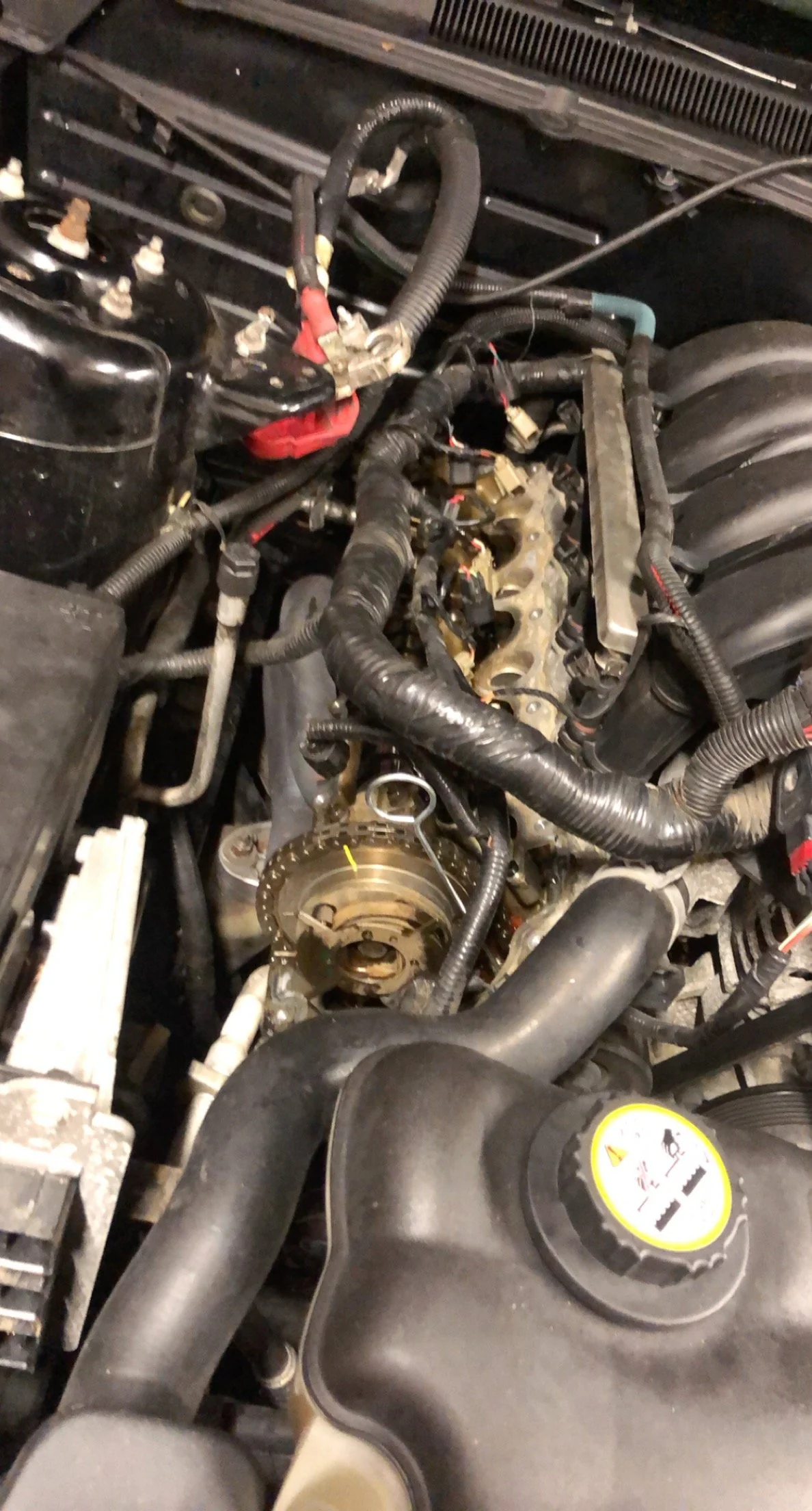 Car engine with parts removed, showing engine block and surrounding components.