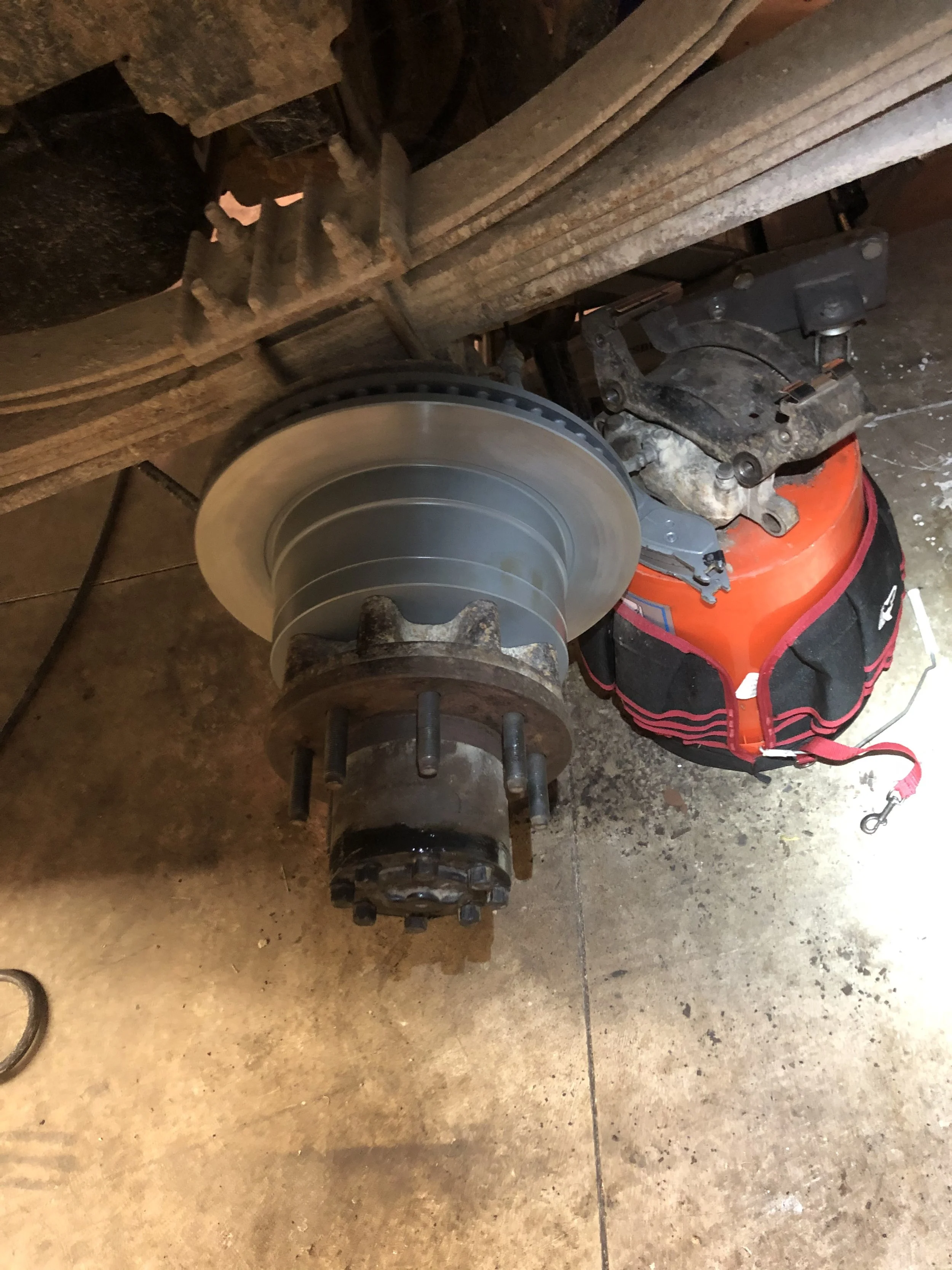 A vehicle's wheel hub with brake rotor attached, mounted on a vehicle lifted off the ground.