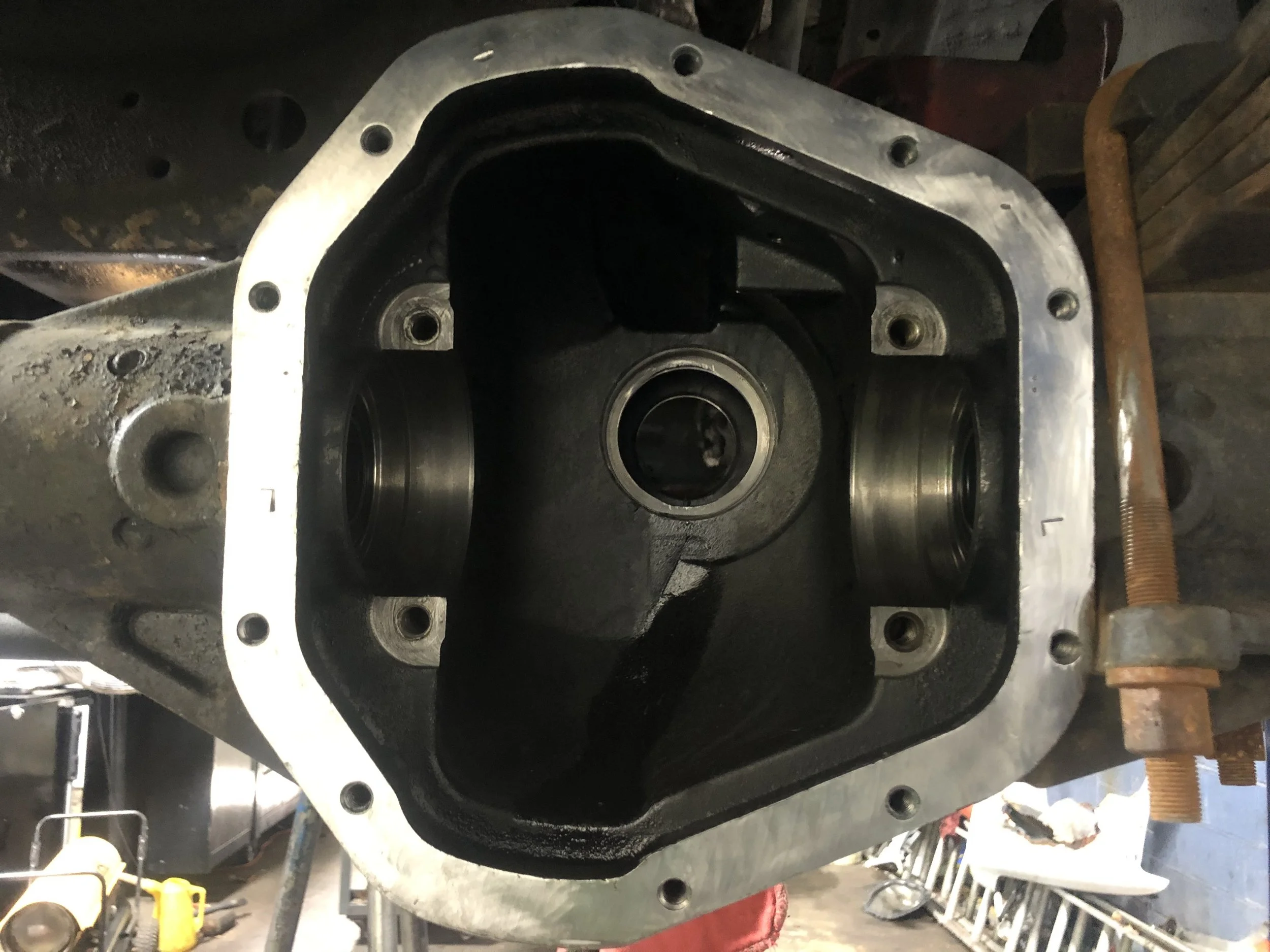 Close-up of a disassembled engine block with visible cylinder openings and bearing surfaces, part of a mechanical repair or rebuild process.