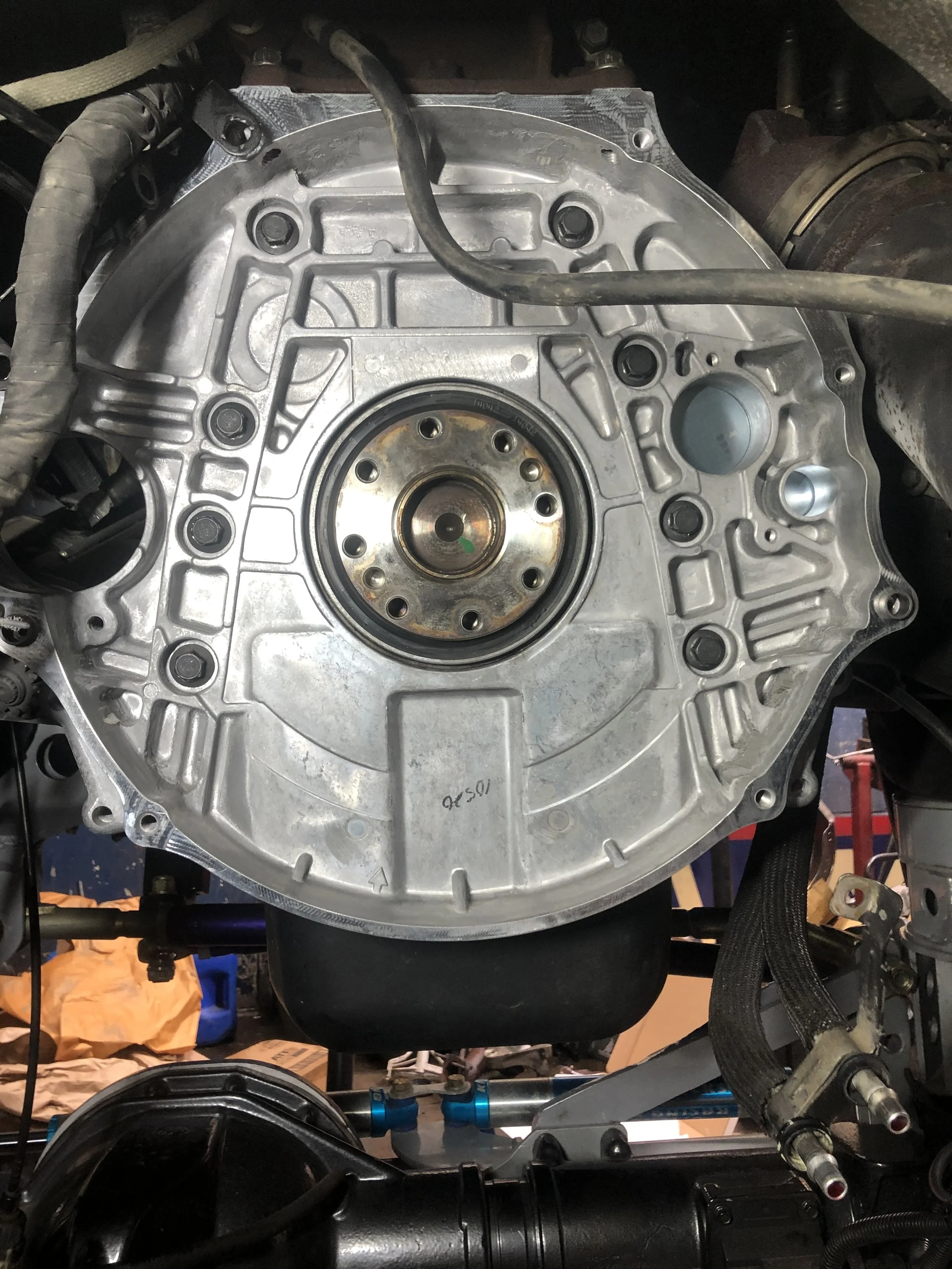 A close-up of a car's transmission housing and internal components, with various mechanical parts and wiring visible.