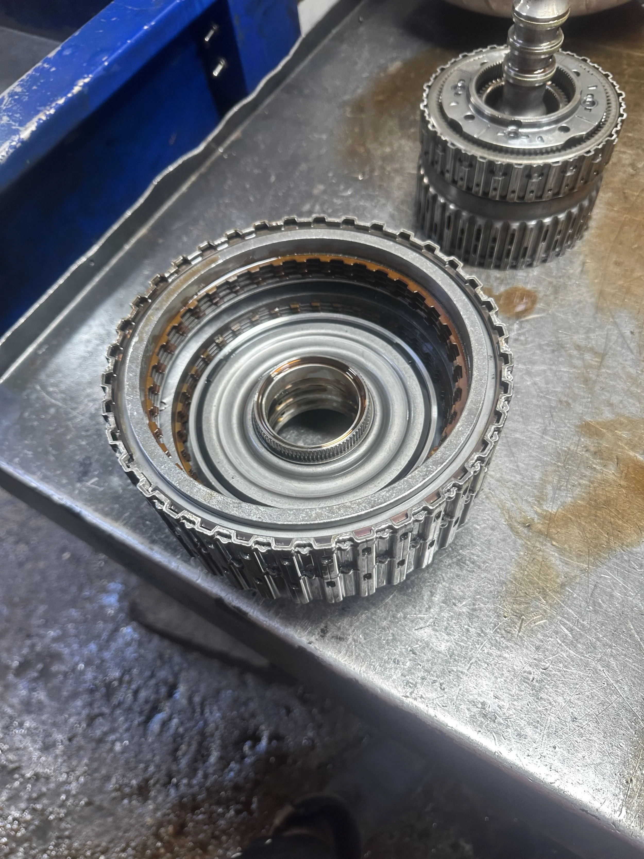 Automobile transmission gears and components on a workbench at a repair shop.