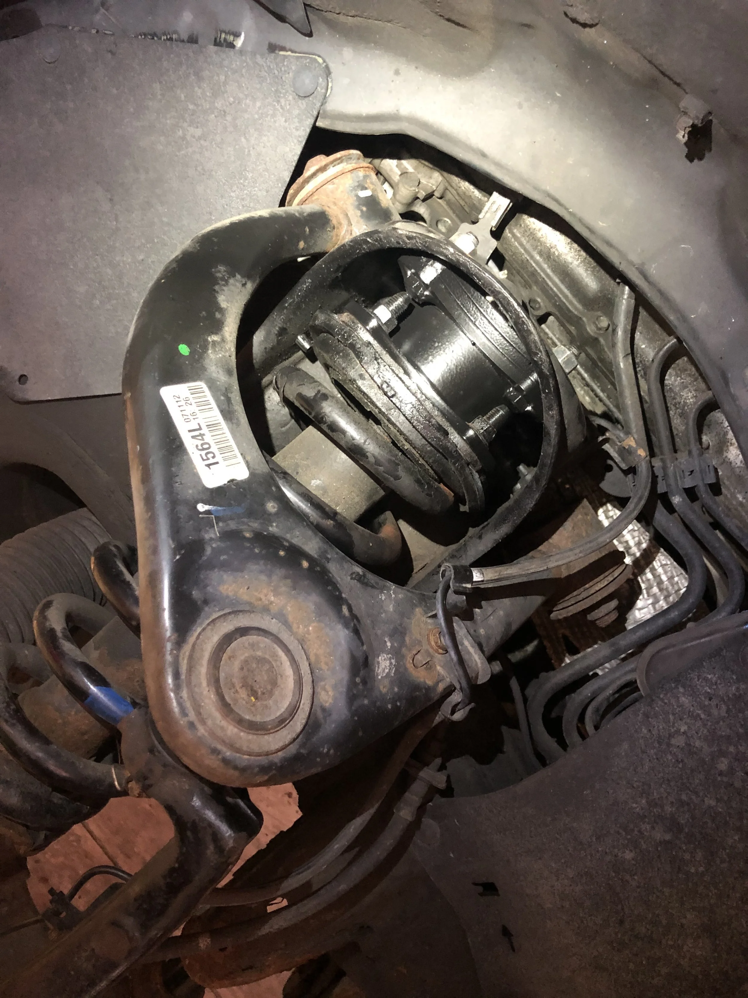 View of a vehicle's wheel hub assembly with suspension components and surrounding parts visible, indicating the wheel has been removed for maintenance or repair.